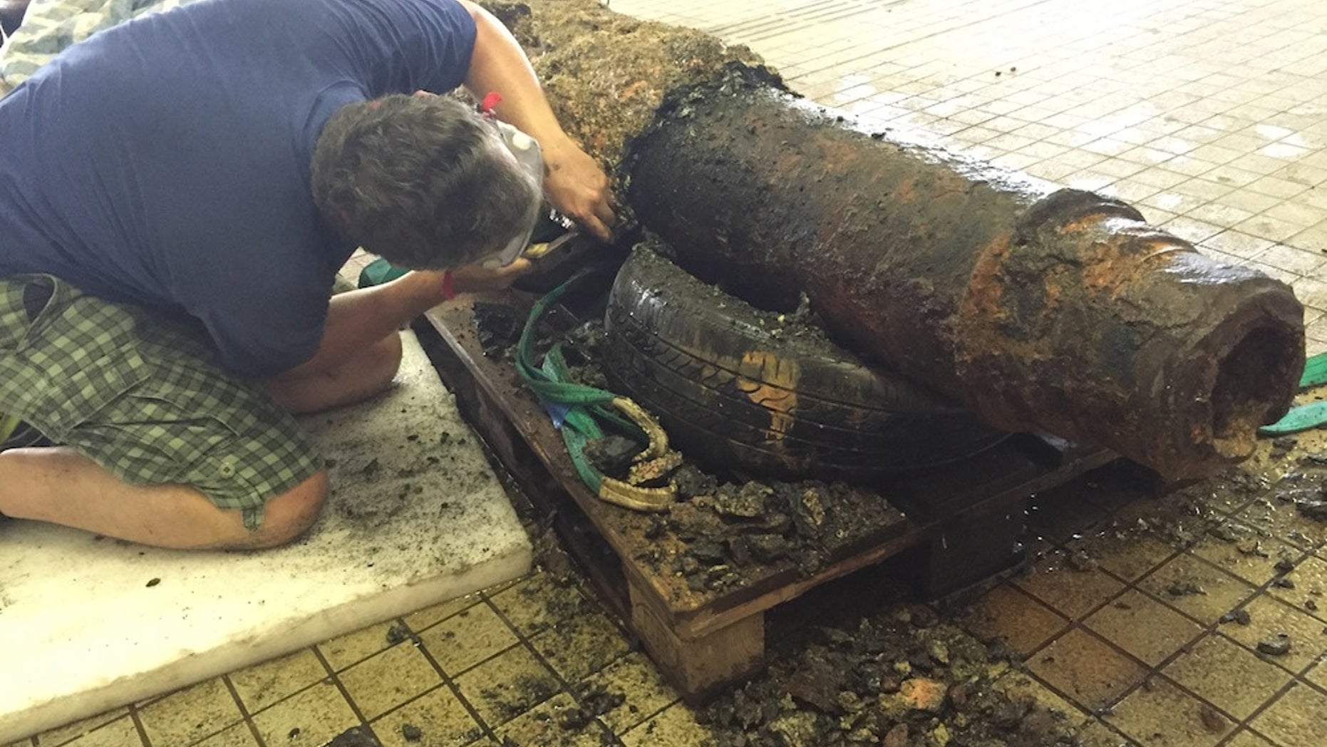 Paul Harrison, a conservator at the Hong Kong Maritime Museum, removes centuries of seabed concretions from the cannon.