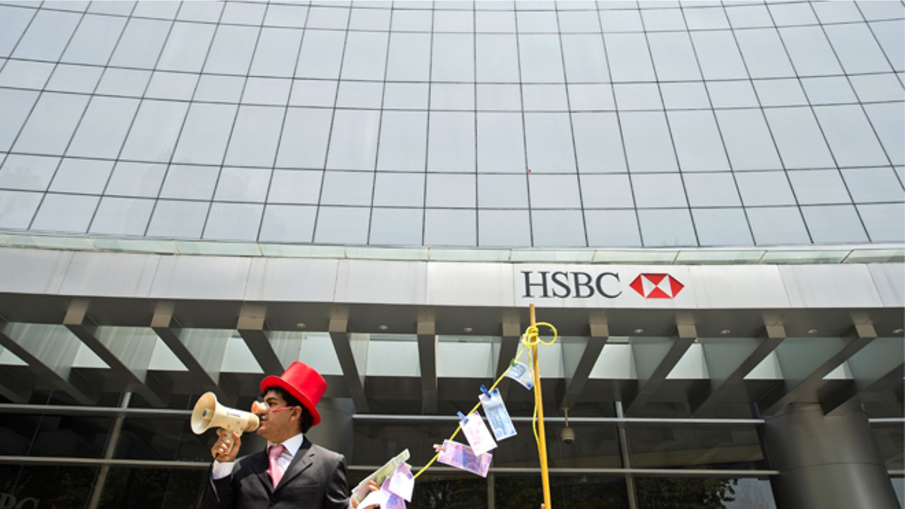 A man weraing a pig nose and holding fake notes shouts slogans during a protest in front of a HSBC branch building, in Mexico City on July 30, 2012. HSBC said on July 30 it took a provision of 700 USD million (571 million euros) to cover fines for failing to apply anti-money laundering rules and warned the overall cost could be "significantly higher." AFP PHOTO/Alfredo ESTRELLA (Photo credit should read ALFREDO ESTRELLA/AFP/GettyImages)