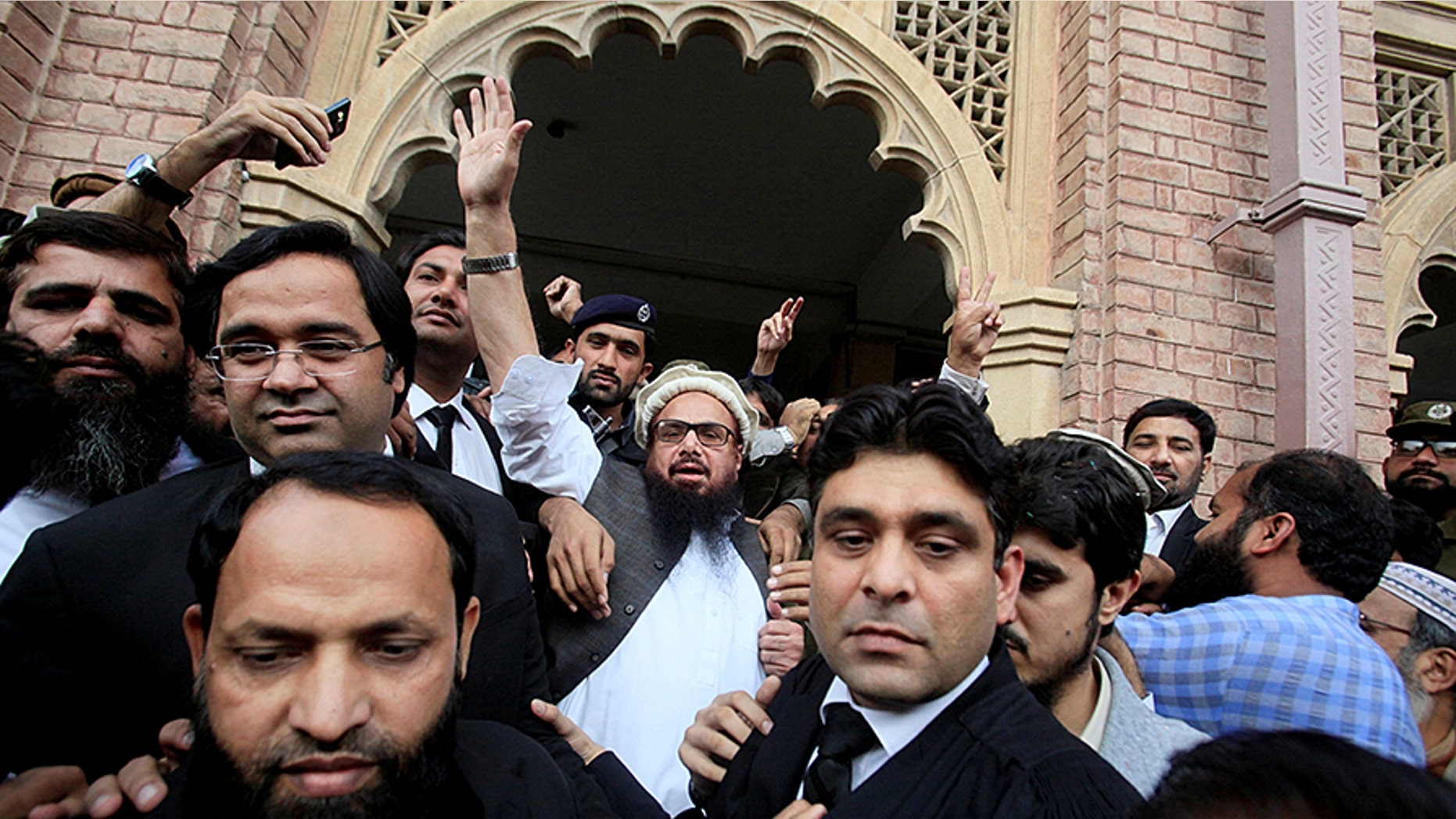 Hafiz Saeed (C) reacts to supporters as he walks out of court after a Pakistani court ordered his release from house arrest in Lahore, Pakistan November 22, 2017. REUTERS/Mohsin Raza - RC150D8E1EA0