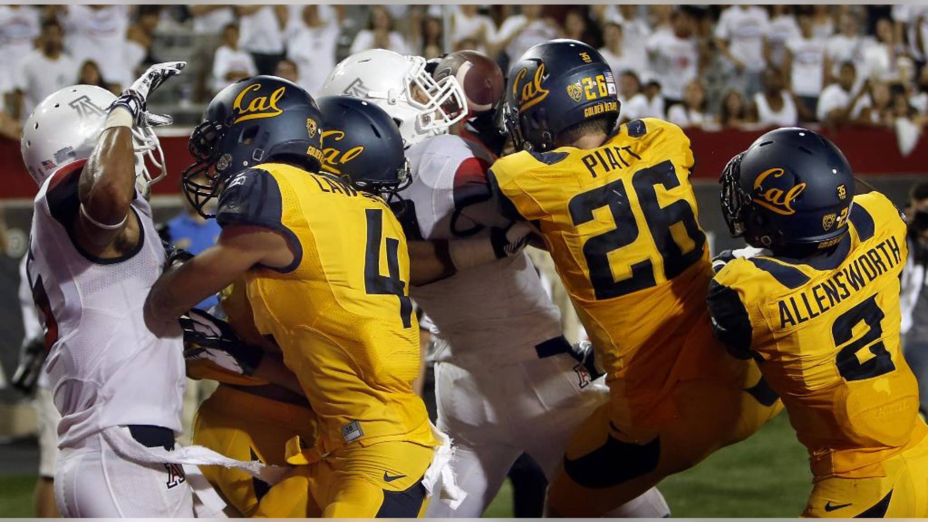 In this Sept. 20, 2014, photo, Arizona running back Austin Hill, center in white, catches a pass for a touchdown in the middle of California defenders including Kenny Lawler (4), Griffin Piatt (26) and Darius Allensworth (2) with no time left on the clock at Arizona Stadium in Tucson, Ariz. Anu Solomon hit Hill with the 47-yard Hail Mary to send the stunned Bears to a 49-45 loss. One part planning and two parts_ at least_ luck, that desperation heave to the end zone rarely results in a touchdown. (AP Photo/Arizona Daily Star, Kelly Presnell ) ALL LOCAL TELEVISION OUT; PAC-12 OUT; MANDATORY CREDIT