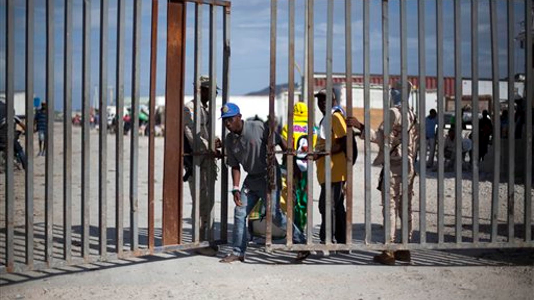 In this Nov. 12, 2013 photo, a Haitian man crosses into Haiti along the border with Jimani, Dominican Republic.