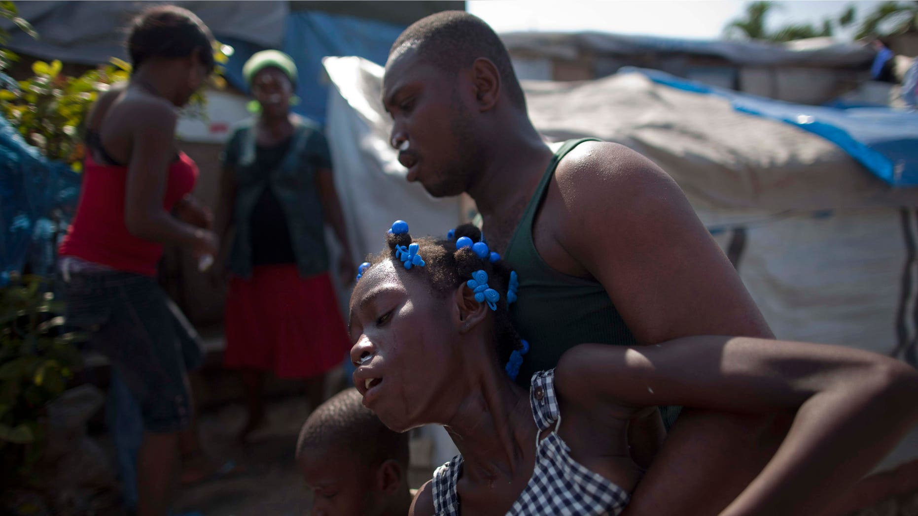 Refugees react to the effects of tear gas fired by police and UN soldiers during a protest in an area where displaced earthquake survivors live in Port-au-Prince, Haiti, Thursday, Nov. 18, 2010. Following days of rioting in northern Haiti over suspicions that U.N. soldiers introduced a cholera epidemic that has killed more than 1,000 people, protesters in Haiti's capital clashed with police Thursday lashing out at U.N. peacekeepers and the government, blocking roads and attacking foreigners' vehicles. (AP Photo/Emilio Morenatti) (AP Photo/Ramon Espinosa)