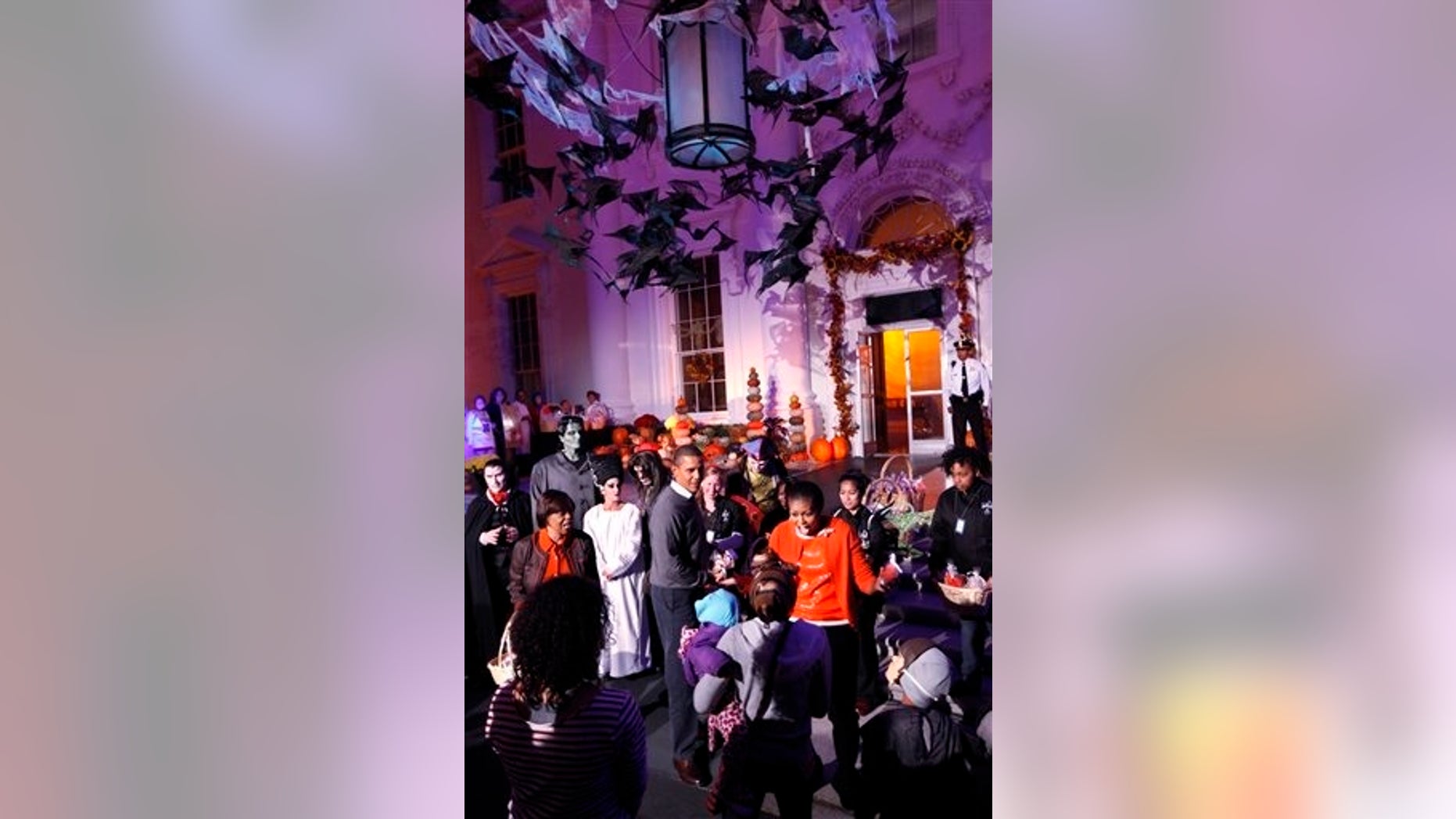 President Barack Obama and first lady Michelle Obama hand out Halloween treats as they welcome children from Washington area and military members and their families to trick-or-treat at the White House, Oct. 31, 2010. (AP Photo)
