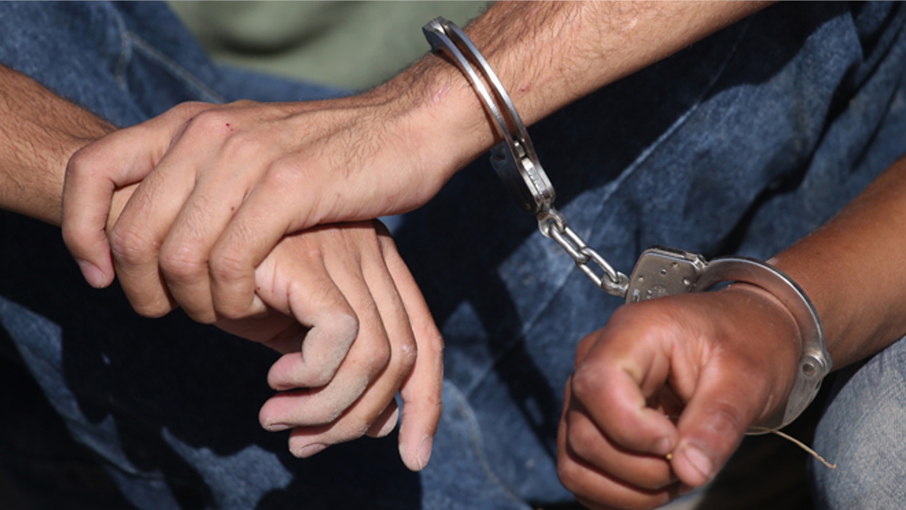 MISSION, TX - APRIL 11: Undocumented immigrants from El Salvador sit handcuffed after being detained by the U.S. Border Patrol near the U.S.-Mexico border on April 11, 2013 near Mission, Texas. A group of 16 immigrants from Mexico and El Salvador said they crossed the Rio Grande River from Mexico into Texas during the morning hours before they were caught. The Rio Grande Valley sector of has seen more than a 50 percent increase in illegal immigrant crossings from last year, according to the Border Patrol. Agents say they have also seen an additional surge in immigrant traffic since immigration reform negotiations began this year in Washington D.C. Proposed refoms could provide a path to citizenship for many of the estimated 11 million undocumented workers living in the United States. Photo by John Moore/Getty Images) (Photo by John Moore/Getty Images)
