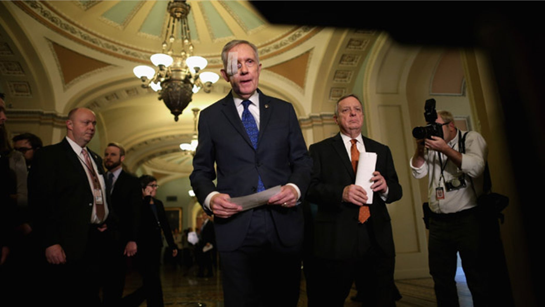 WASHINGTON, DC - FEBRUARY 03: Senate Minority Leader Harry Reid (D-NV) (C) and Senate Minority Whip Richard Durbin (D-IL) (2nd R) arrive for a news conference after the weekly Democratic Senate policy luncheon at the U.S. Capitol February 3, 2015 in Washington, DC. Reid is wearing a bandage over his right eye after undergoing surgery to repair damage from an exercise accident. (Photo by Chip Somodevilla/Getty Images)