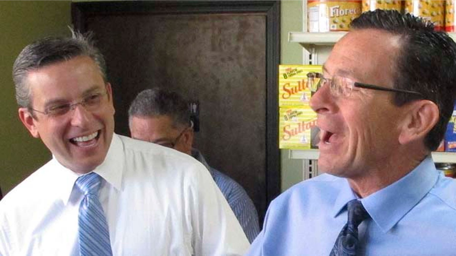 FILE - In this Oct. 28, 2014 file photo, Hartford Mayor Pedro Segarra, right, accompanies Connecticut Gov. Dannel P. Malloy as he campaigns in Hartford, Conn. At left is Puerto Rico Gov. Alejandro Garcia Padilla. Segarra, a Democrat, is the second consecutive Puerto Rico-born mayor of Hartford, and is counting on votes from the city's Latino community as he seeks re-election in 2015. (AP Photo/Dave Collins, File)