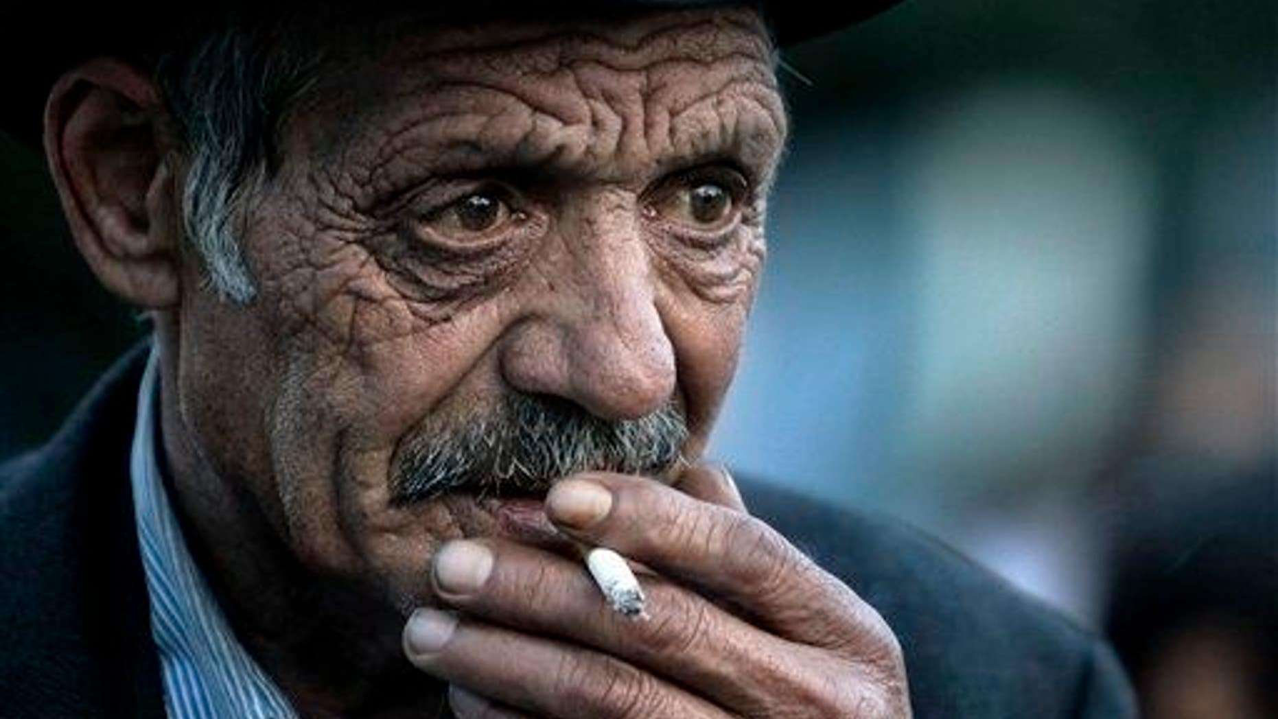 An elderly man smokes.