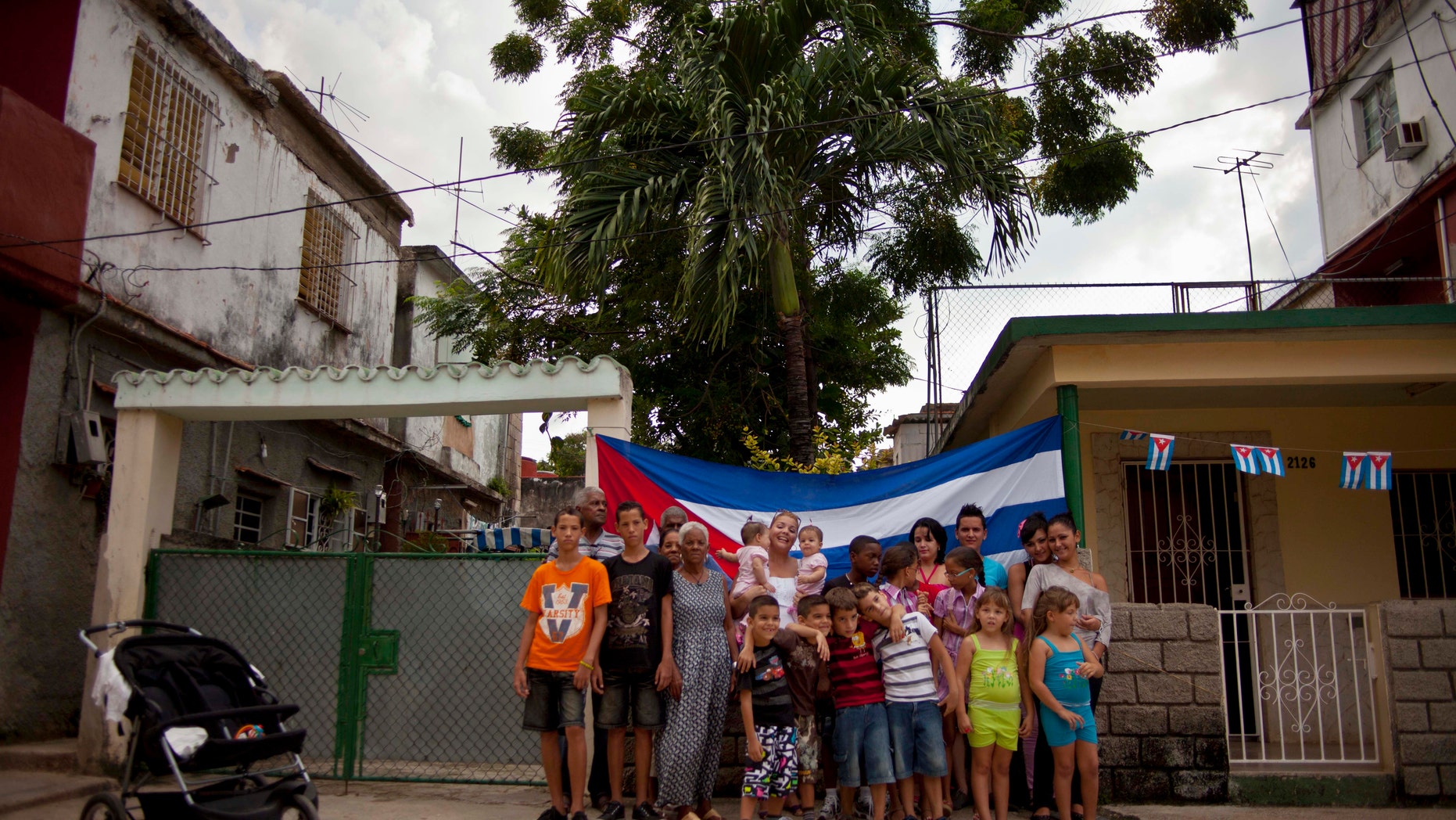 Pairs of twins pose for a group portrait near a Siguaraya tree along their street in Havana, Cuba.