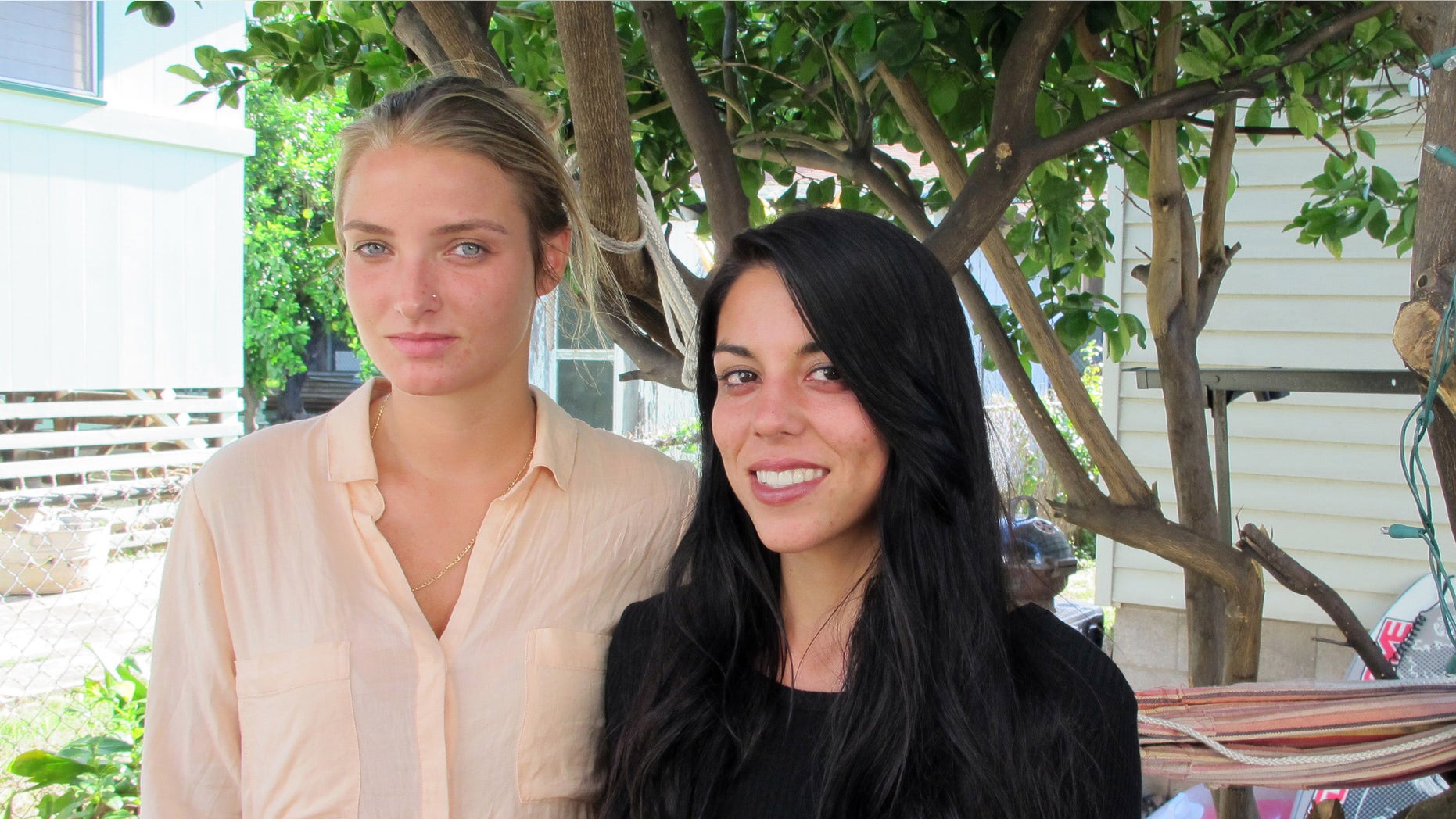 File-This Oct. 28, 2015, file photo shows Courtney Wilson, left, and Taylor Guerrero posing for a photo in Honolulu. Honolulu will pay $80,000 to settle a lesbian couple's lawsuit alleging a city's police officer wrongfully arrested them after seeing them kissing in a grocery store while on vacation. The settlement was announced Friday, May 20, 2016, in federal court in Honolulu. It's still subject to City Council approval. Wilson and Guerrero were visiting Hawaii form Los Angeles last year when they say they were harassed and arrested because the officer didn't like their public displays of affection in a Foodland store on Oahu's North Shore. (AP Photo/Jennifer Sinco Kelleher, File)