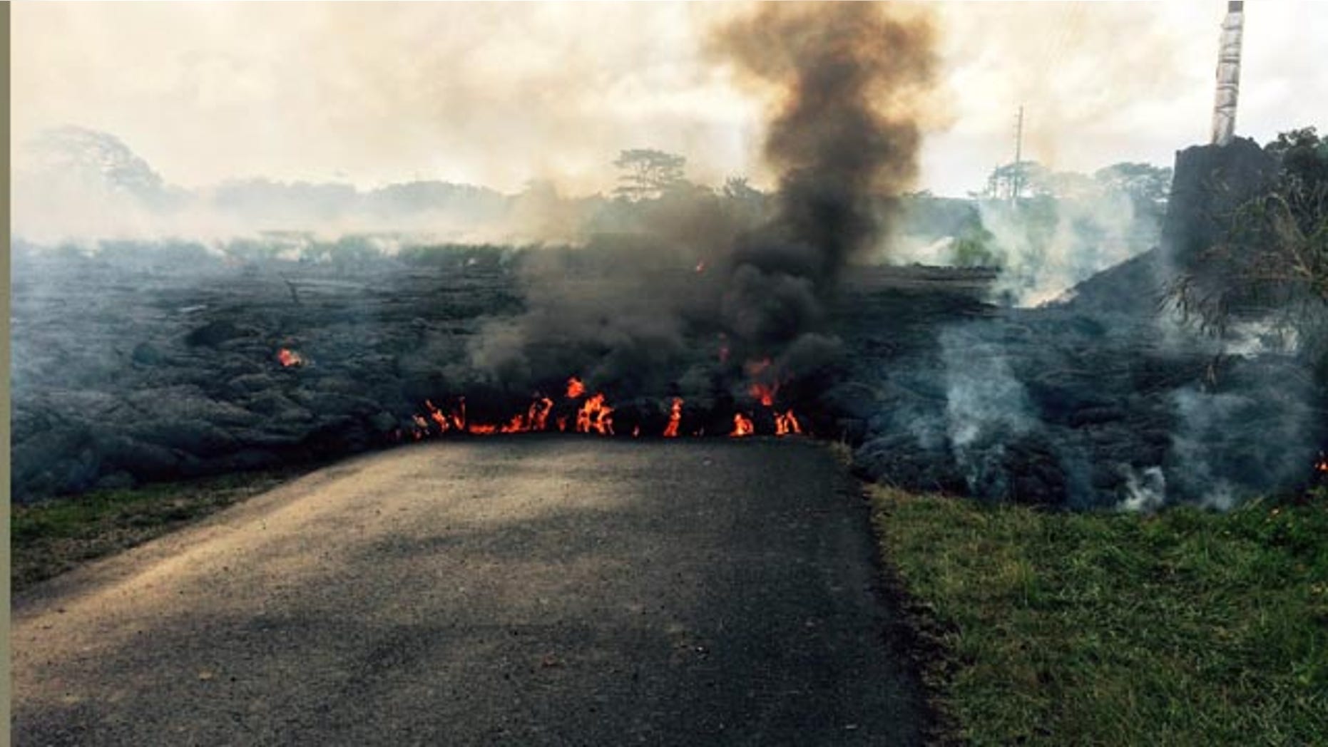 October 24, 2014: In this photo from the U.S. Geological Survey, the lava flow from Kilauea Volcano that began June 27 is seen as it crossed Apa'a Street near Cemetery Road near the town of Pahoa on the Big Island of Hawaii. (AP/U.S. Geological Survey)