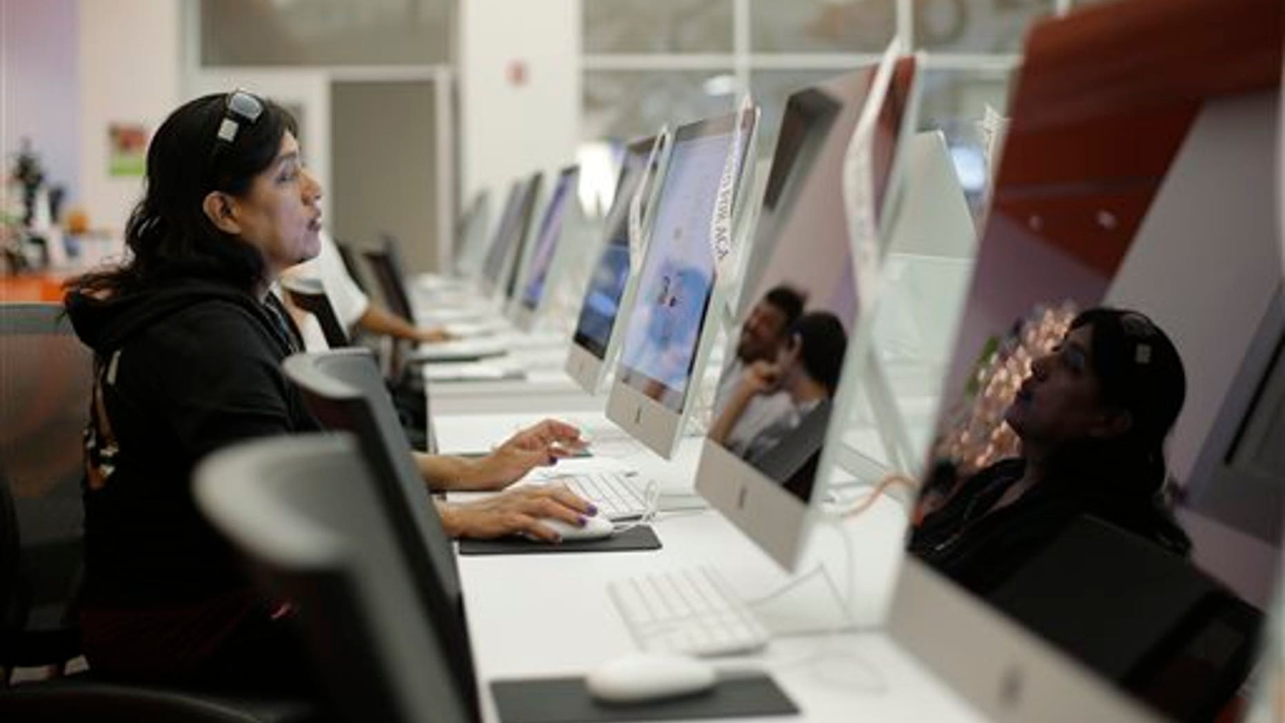 FILE - In this Dec. 11, 2013, file photo, Rosemary Cabelo uses a computer at a public library to access the Affordable Health Care Act website in San Antonio. The Obama administration says following a December surge, more than 1.1 million people have now enrolled for health insurance through the federal governments improved website. (AP Photo/Eric Gay, File)