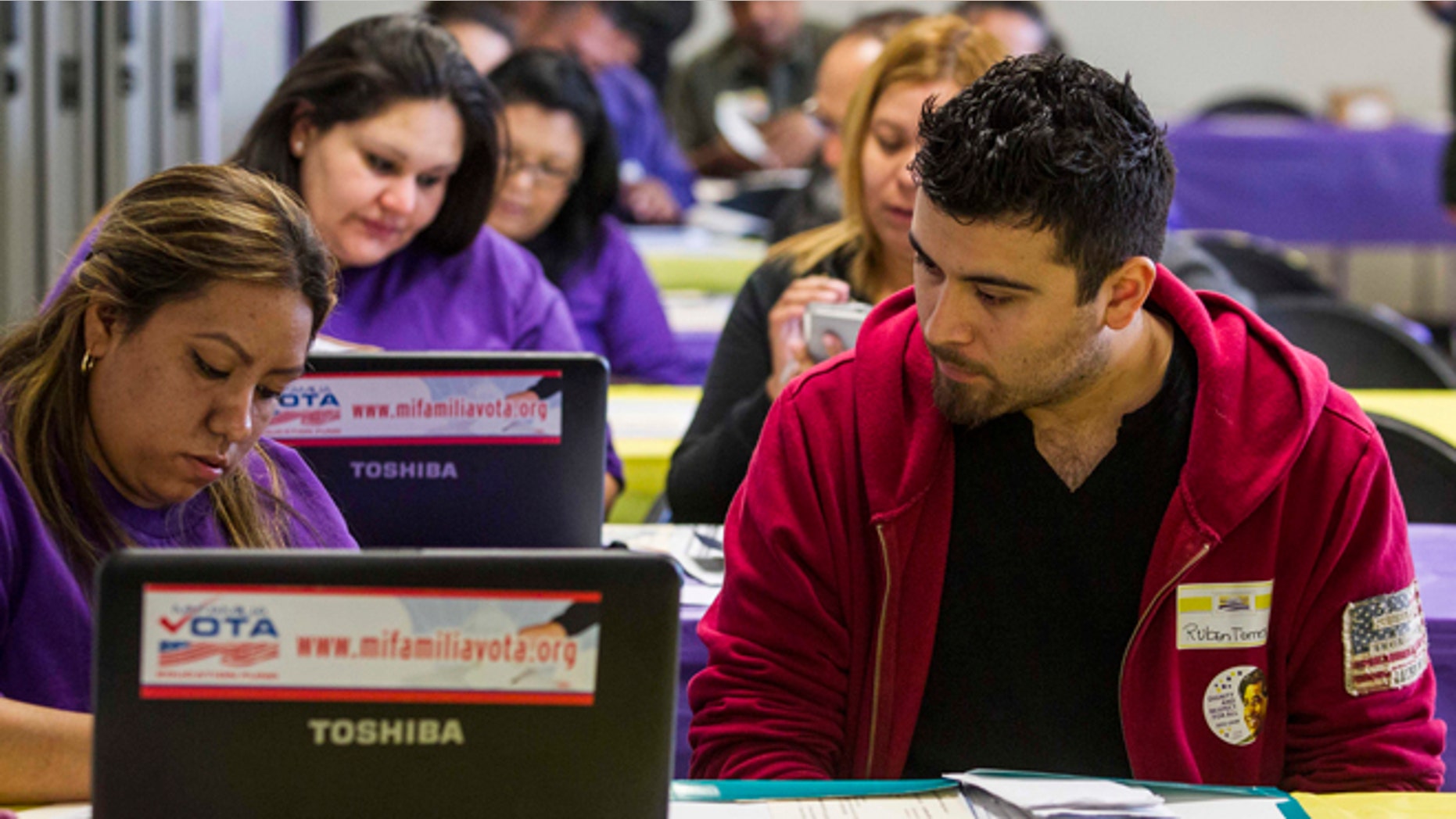 SEIU-UHW worker Kathy Santana, left , assists Ruben Torres, 27, during a health care enrollment event at SEIU-UHW office, Monday, March 31, 2014, in Commerce, Calif. Monday is the deadline to sign up for private health insurance in the new online markets created by President Barack Obama's health care law. (AP Photo/Ringo H.W. Chiu)
