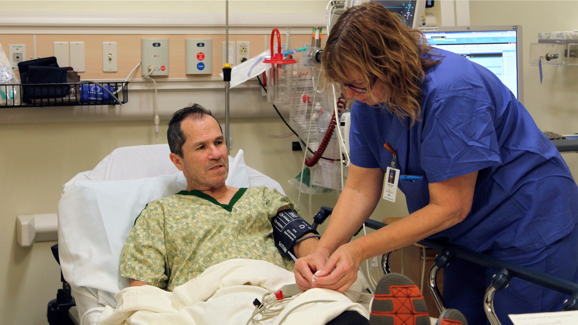 In this Wednesday, Dec. 3, 2014 photo, a nurse prepares liver cancer patient Crispin Lopez Serrano for an endoscopy at a Clackamas, Ore. hospital. Lopez Serrano, a Mexican native who is fully bilingual, says his care improved after he received culturally relevant palliative care from a Portland nonprofit organization, helping him to retain his doctors, boost his health literacy, and receive emotional support. (AP Photo/Gosia Wozniacka)