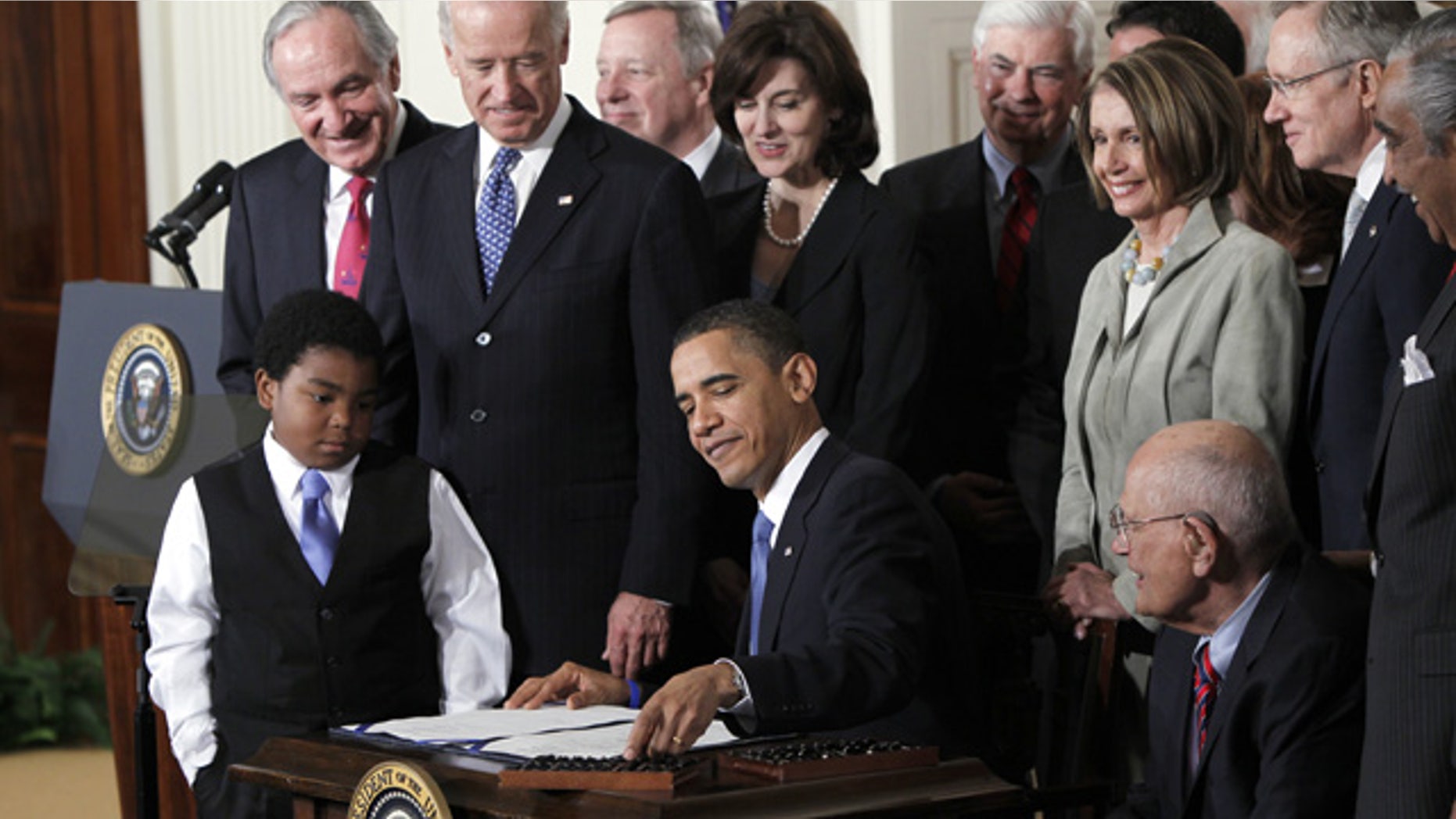 FILE - In this March 23, 2010, file photo, President Barack Obama reaches for a pen to sign the health care bill in the East Room of the White House in Washington. (AP Photo/Charles Dharapak, File)