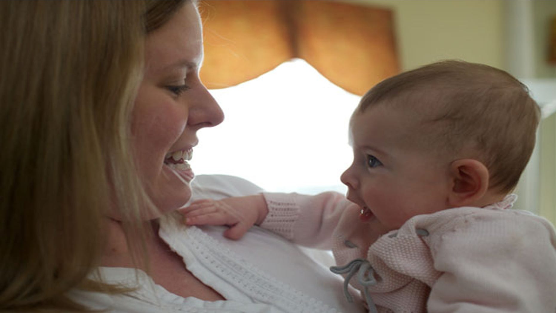 In this photo taken Sept. 24, 2013, Holly Sloan interacts with her baby Amelia at their home in Warrenton, Va. Ameliaâs family enrolled in a study that is deciding the DNA of babies, as researchers explore whether gene-mapping one day should become a part of newborn care.