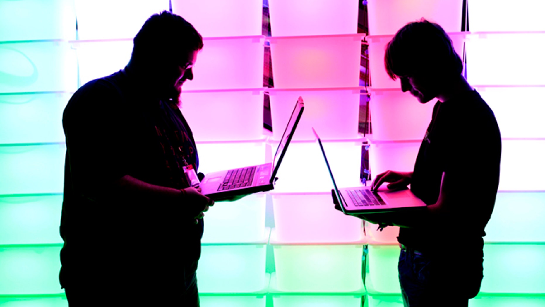 HAMBURG, GERMANY - DECEMBER 28: Participant hold their laptops in front of an illuminated wall at the annual Chaos Computer Club (CCC) computer hackers' congress, called 29C3, on December 28, 2012 in Hamburg, Germany. The 29th Chaos Communication Congress (29C3) attracts hundreds of participants worldwide annually to engage in workshops and lectures discussing the role of technology in society and its future. (Photo by Patrick Lux/Getty Images)