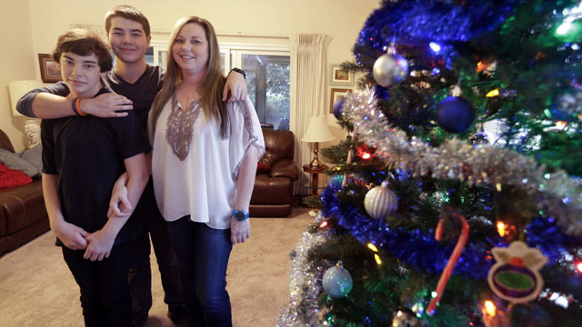 December 17, 2013: Matthew Kremis, center, poses for a picture with his brother Trevin Kremis, left, and their mother, Deanna Kremis, in their home in San Marcos, Calif. All three have received heart transplants, after suffering from an inherited heart condition. (AP Photo/Gregory Bull)