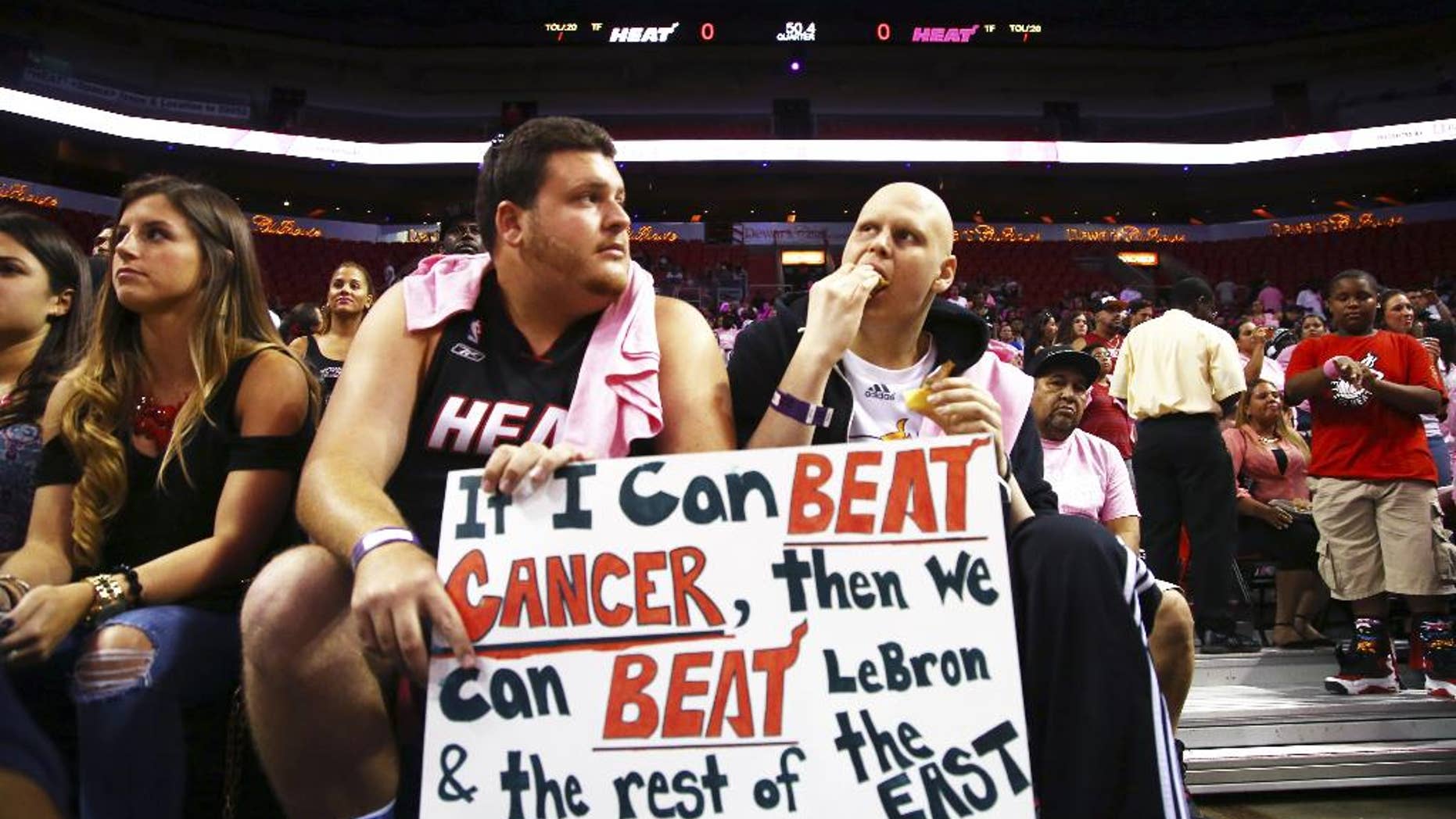 Two fans wait for the start of the Miami Heat's Red, White, and Pink basketball scrimmage Wednesday, Oct. 1, 2014, in Miami. (AP Photo/J Pat Carter)