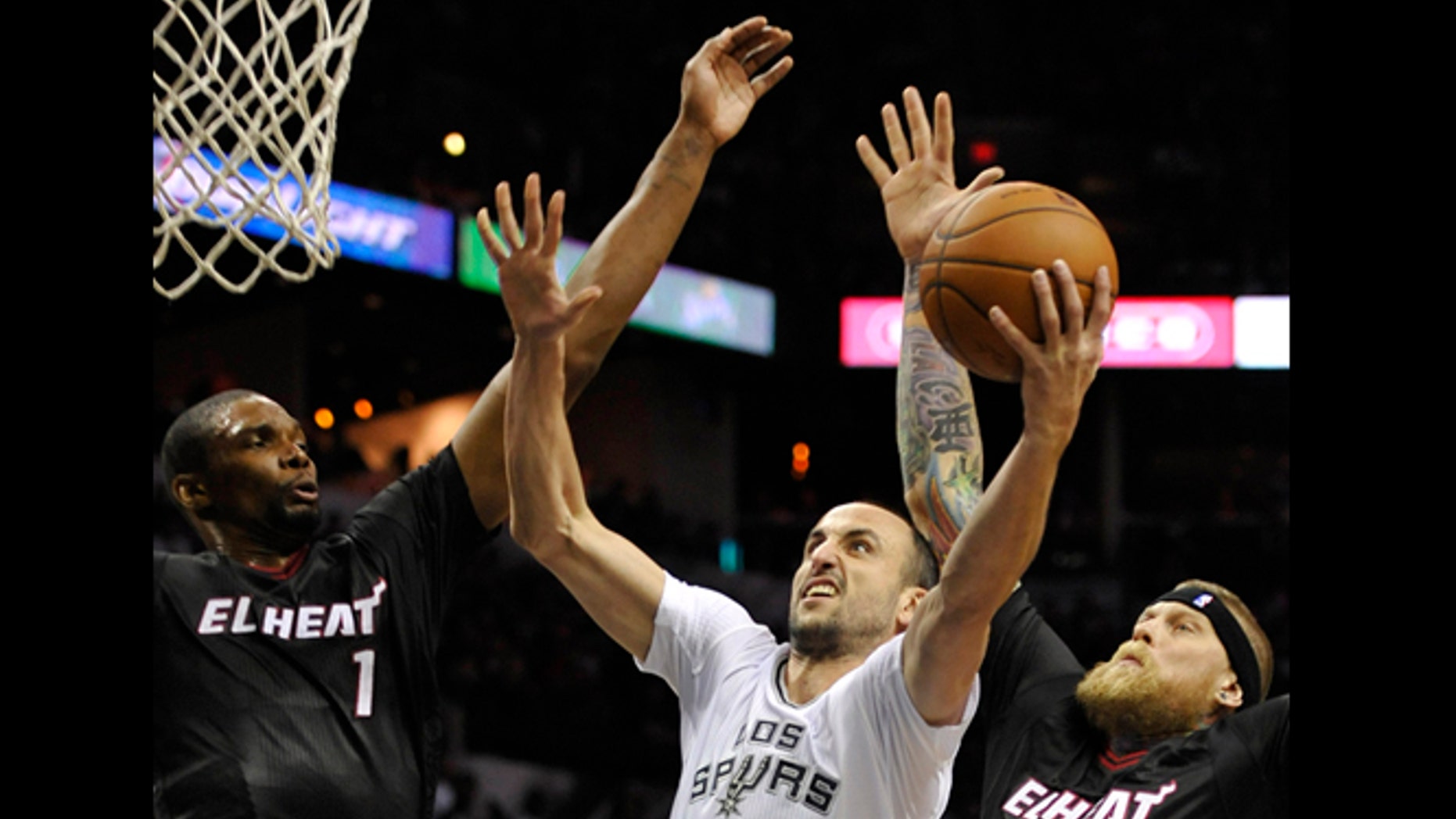 San Antonio Spurs guard Manu Ginobili, center, of Argentina, shoots against Miami Heat forwards Chris Bosh, left, and Chris Andersen, during the first half of an NBA basketball game on Thursday, March 6, 2014, in San Antonio. (AP Photo/Darren Abate)
