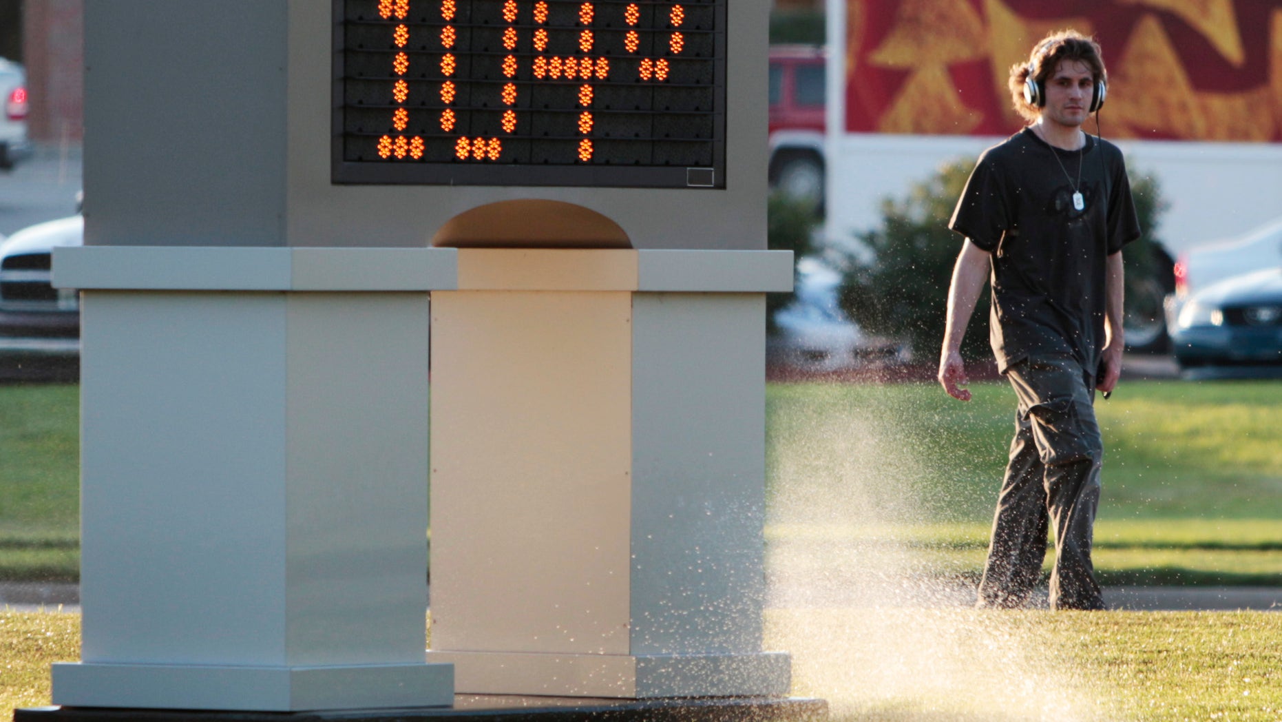 An unidentified pedestrian walks past a time and temperature sign in Lawrence, Kan., Monday, July 11, 2011. Heat advisories and excessive-heat warnings were issued Monday for 17 states in the Midwest and South.