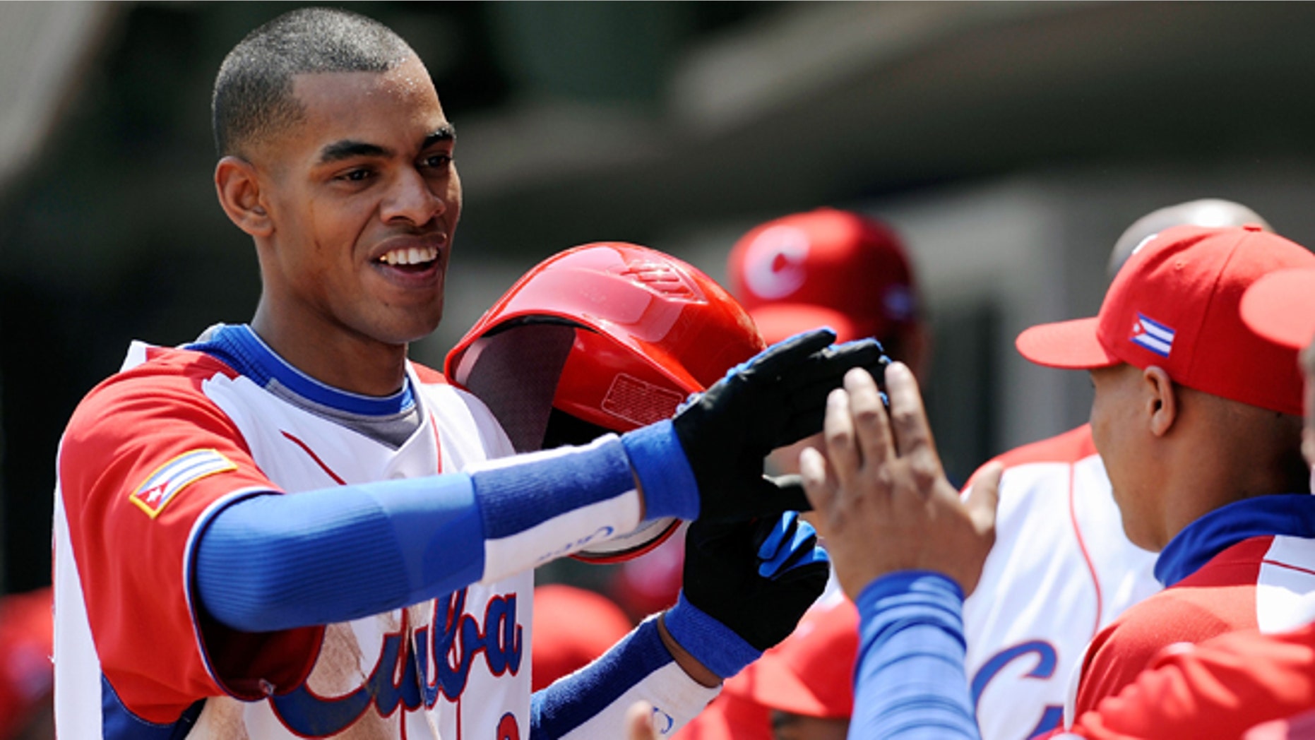 MEXICO CITY - MARCH 08: Hector Olivera #28 of Cuba is congratulated by his teammates after hitting a home run against South Africa during the 2009 World Baseball Classic Pool B match on March 8, 2009 at the Estadio Foro Sol in Mexico City, Mexico. (Photo by Kevork Djansezian/Getty Images) *** Local Caption *** Hector Olivera
