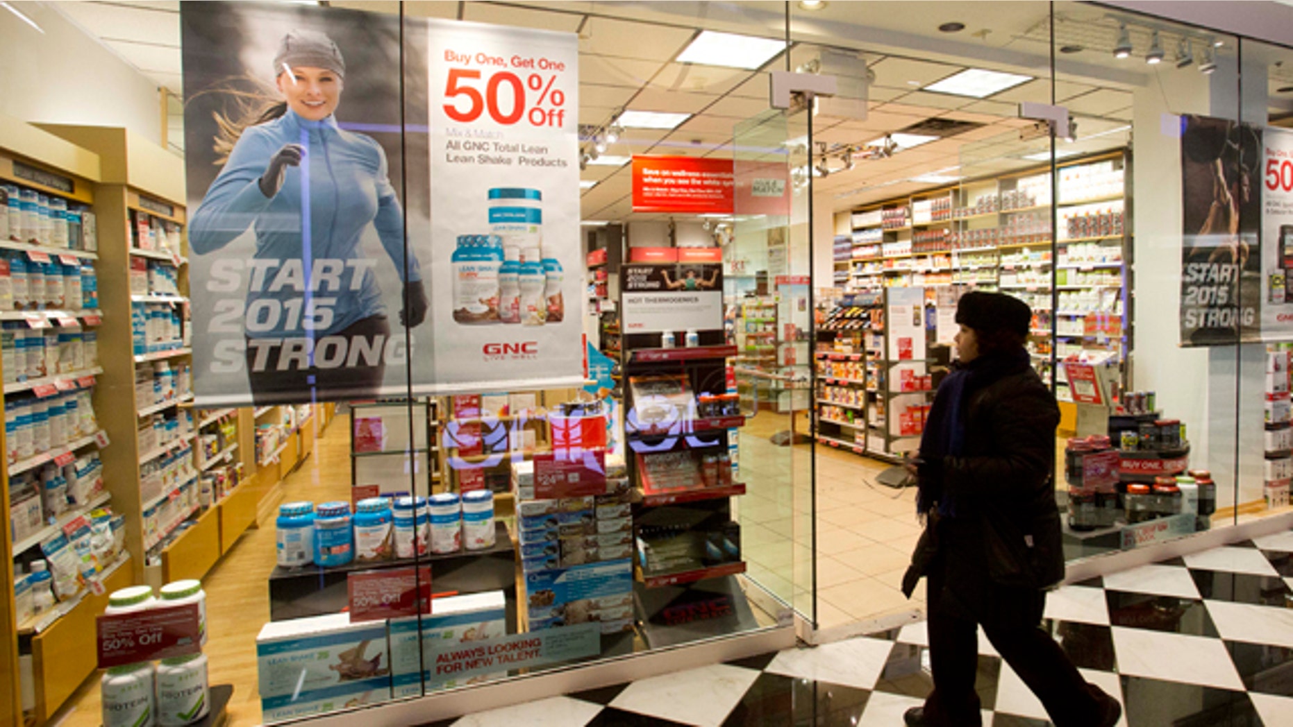 Feb. 3, 2015: A woman walks past a GNC store in New York. (AP Photo/Mark Lennihan)