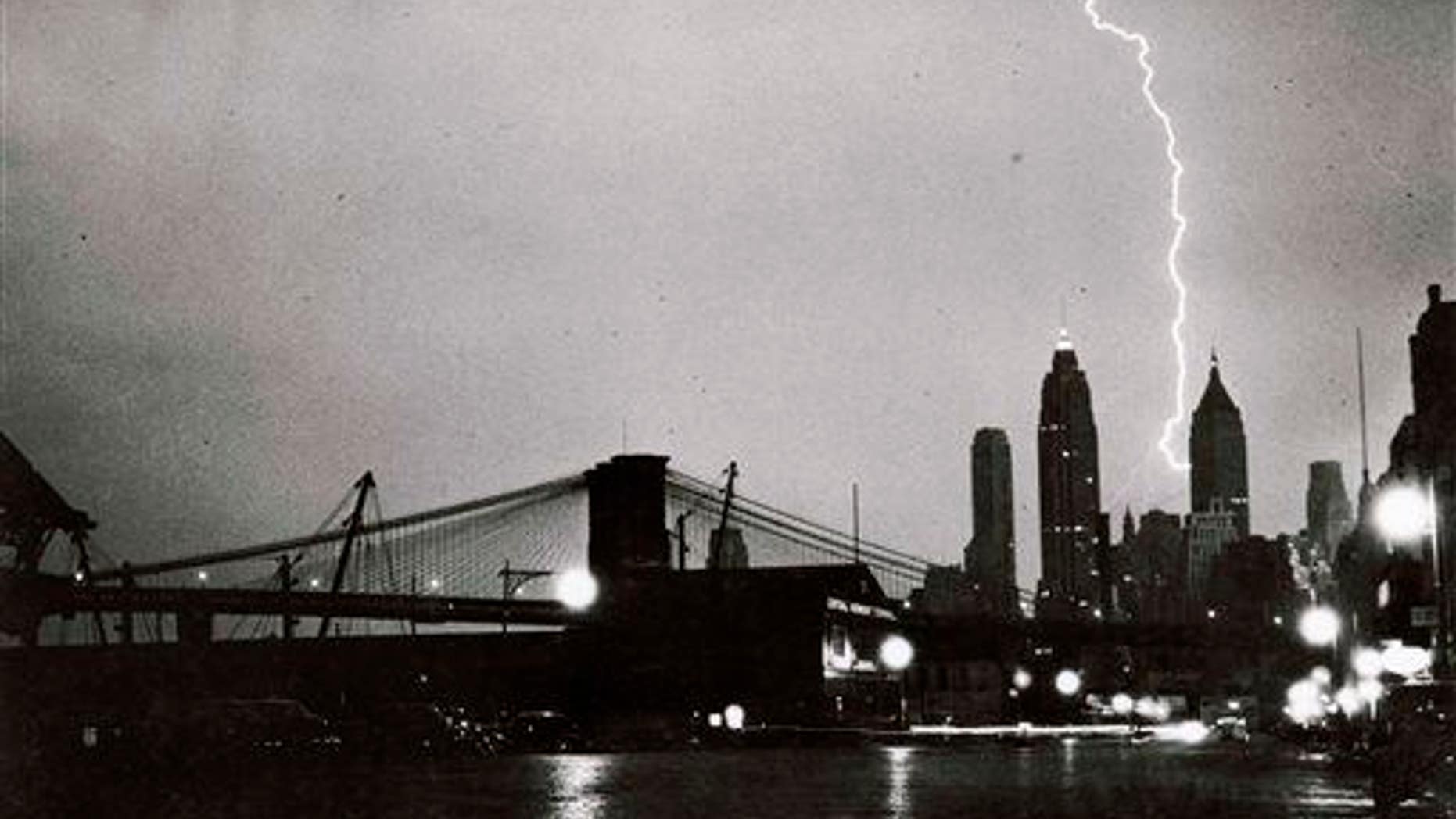 In this July 27, 1940, photo, "Striking Beauty" by Weegee, a bolt of lightning strikes the lower Manhattan skyline near the Brooklyn Bridge.