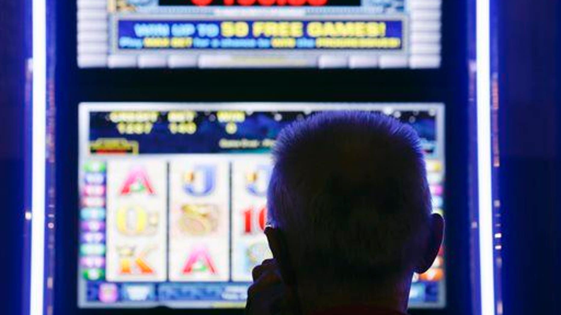In this Oct. 16, 2014 photo, a man plays at a video lottery terminal at Tioga Downs in Nichols, NY.