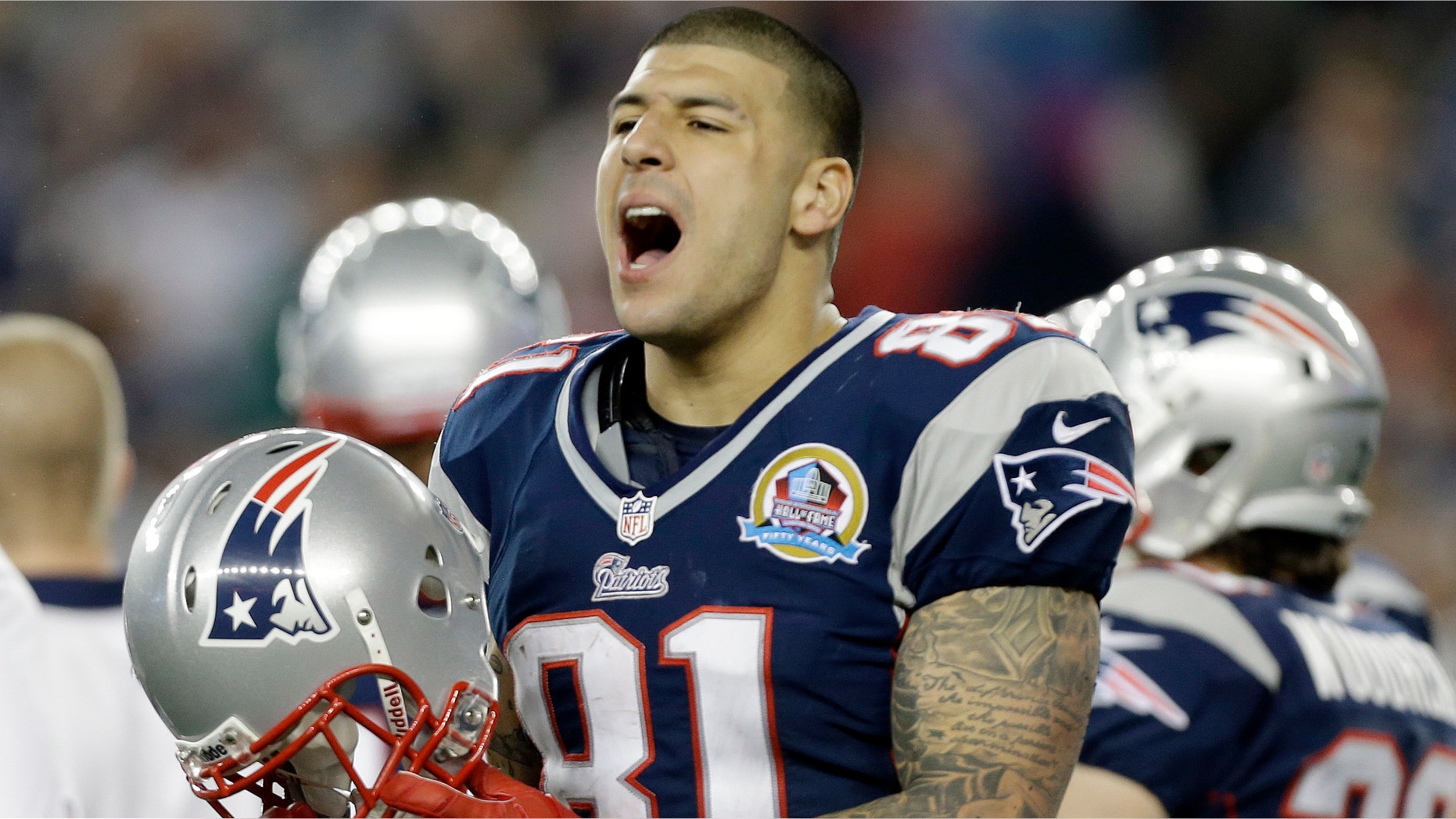 FILE - In this Dec. 10, 2012 file photo, New England Patriots tight end Aaron Hernandez reacts during the second quarter of an NFL football game against the Houston Texans in Foxborough, Mass. State and local police spent hours at the home of New England Patriots tight end Aaron Hernandez on Tuesday June 18, 2013 as another group of officers searched an industrial park about a mile away where a body was discovered the day before. (AP Photo/Elise Amendola, File)