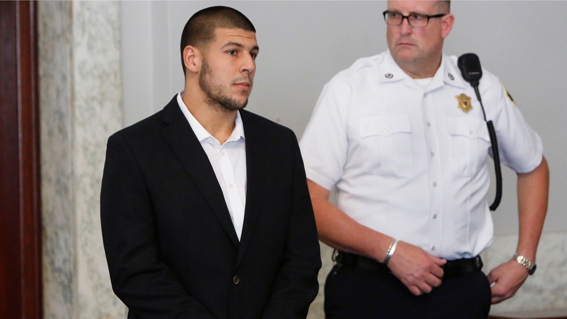 Former New England Patriots NFL football tight end Aaron Hernandez, left, appears at Attleboro District Court on Wednesday, July 24, 2013, in Attleboro, Mass. Hernandez has pleaded not guilty to murder in the death of Odin Lloyd. Hernandez was in court for what was supposed to be a probable cause hearing, but prosecutors said the grand jury is still considering the evidence against him. A judge rescheduled the probable cause hearing for Aug. 22, after considering defense objections to a delay. (AP Photo/Bizuayehu Tesfaye)