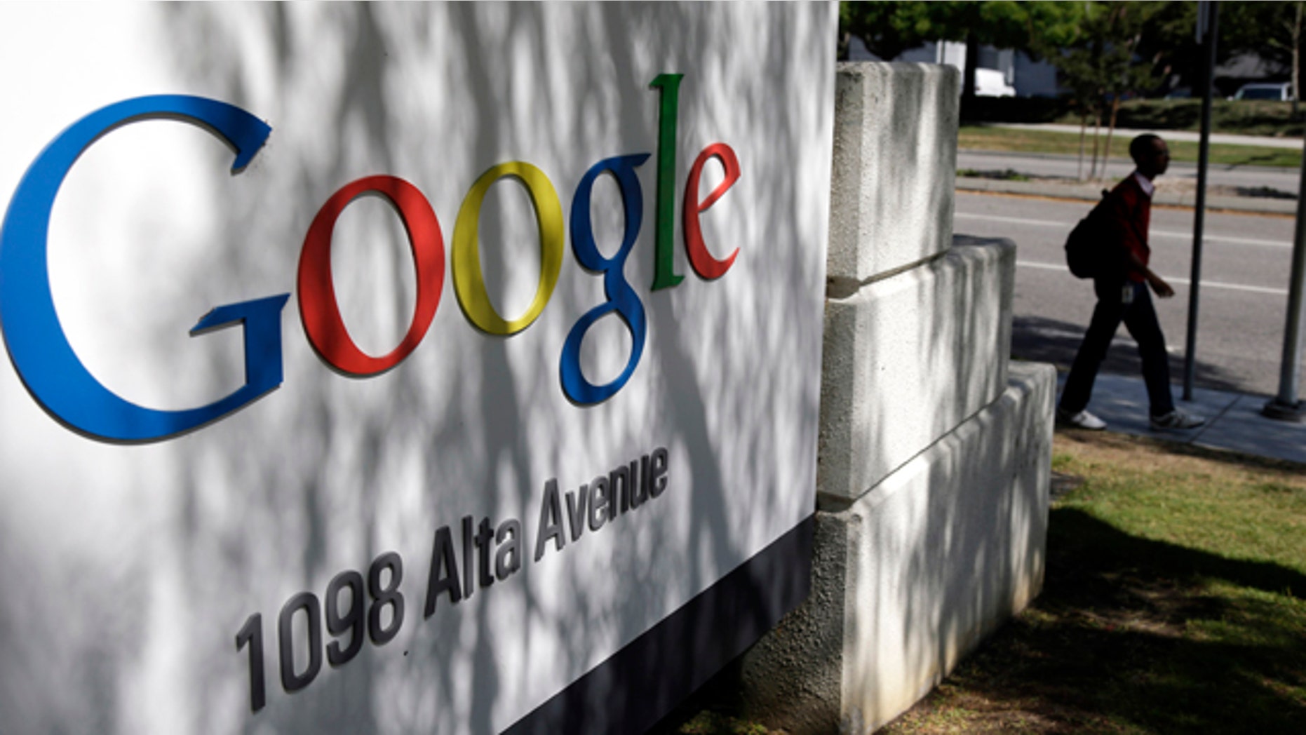 FILE - In this June 5, 2014 file photo, a man walks past a Google sign at the company's headquarters in Mountain View, Calif. (AP Photo/Marcio Jose Sanchez, File)