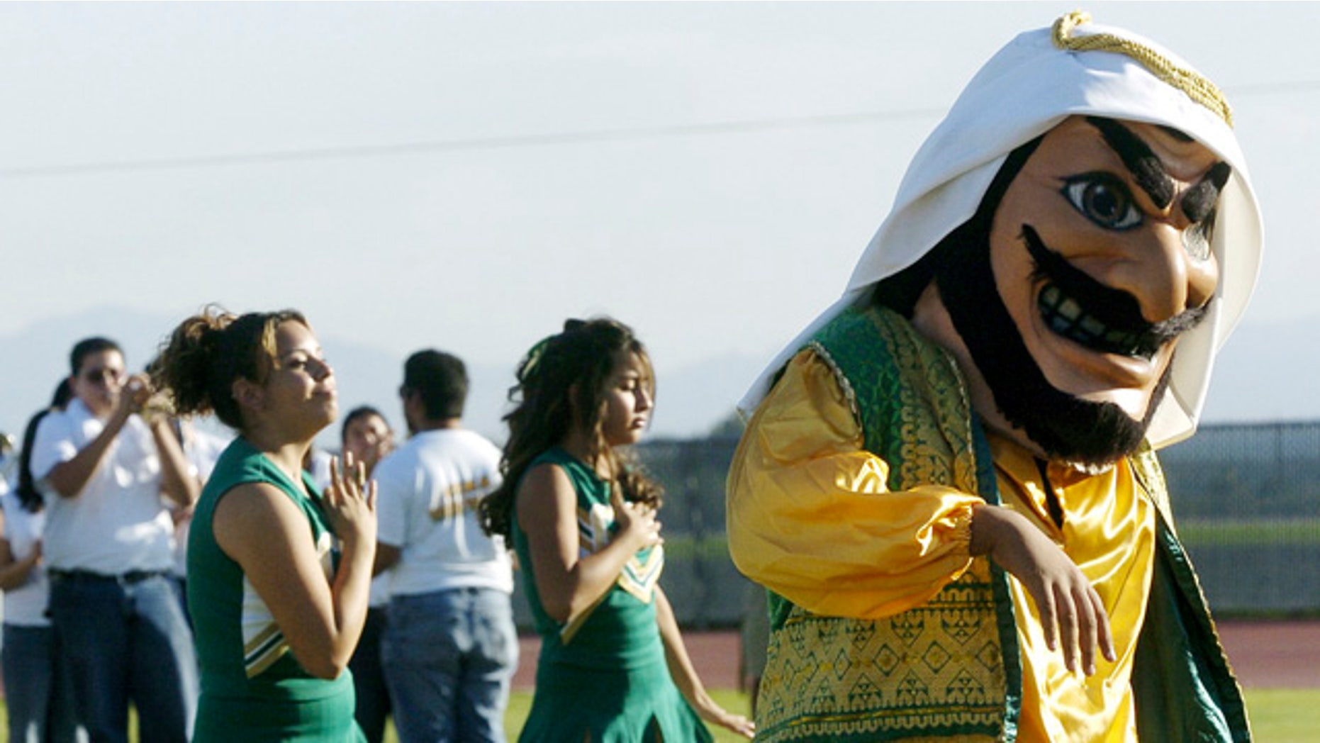 FILE - In this Nov. 10, 2005, file photo, Coachella Valley High School's mascot, 'Arab,' dances to the band during a pep rally at the school in Thermal, Calif. The hook-nosed, snarling mascot who wears a head scarf did not appear at Coachella Valley High School's season opening football game Friday. (AP Photo/The Desert Sun, Marilyn Chung, File)
