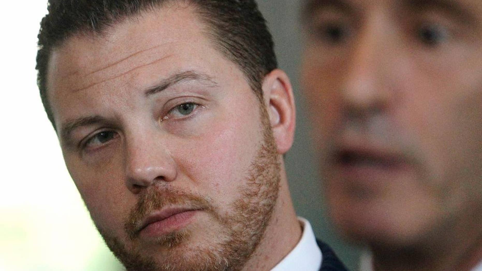 FILE - In this July 29, 2014 file photo, Joseph Siprut, left, attorney to Daniel Bukal, a star quarterback at Notre Dame College Prep in Niles from 1999 to 2003, listens while attorney Steve Berman speaks at a news conference. (AP Photo/Stacy Thacker, File)