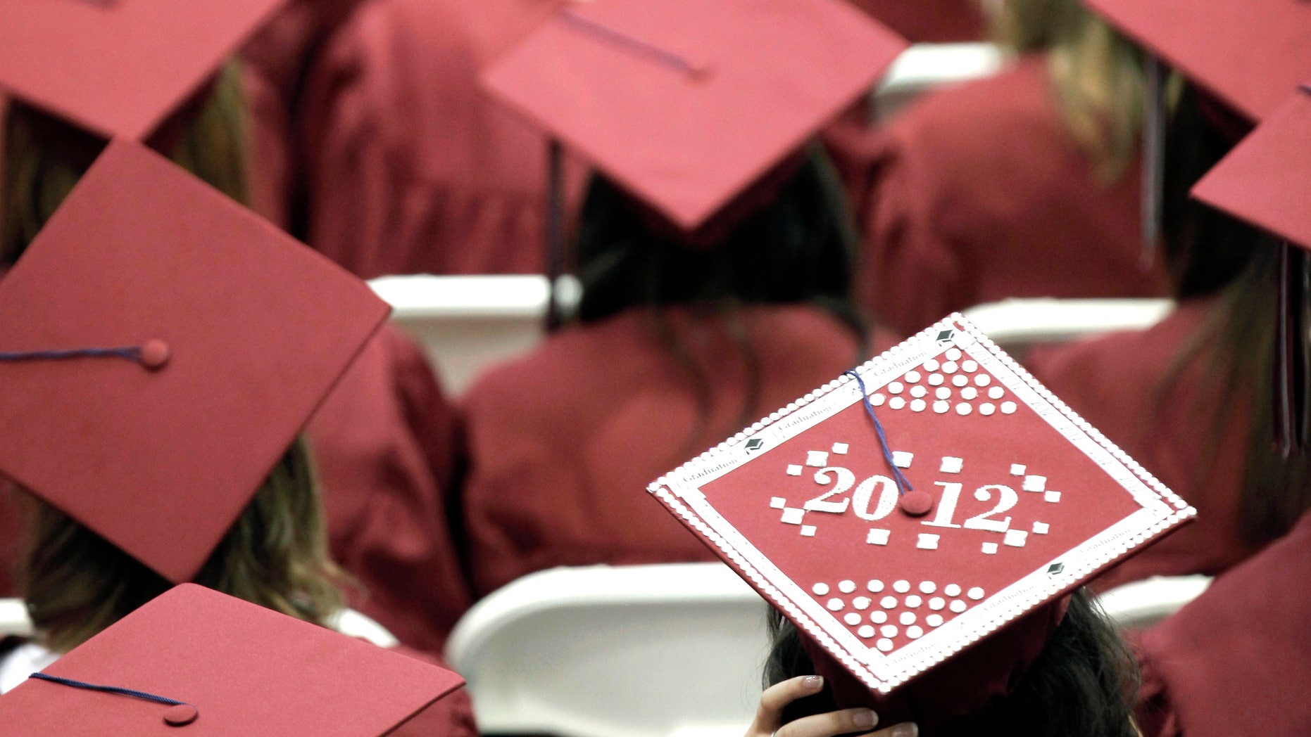 FILE - In this May 21, 2012, file photo, graduates from Joplin High School listen to speakers during commencement ceremonies in Joplin, Mo. U.S. public high schools have reached a milestone, an 80 percent graduation rate. Yet that still means 1 of every 5 students walks away without a diploma. Citing the progress, researchers are projecting a 90 percent national graduation rate by 2020. (AP Photo/Charlie Riedel, File)