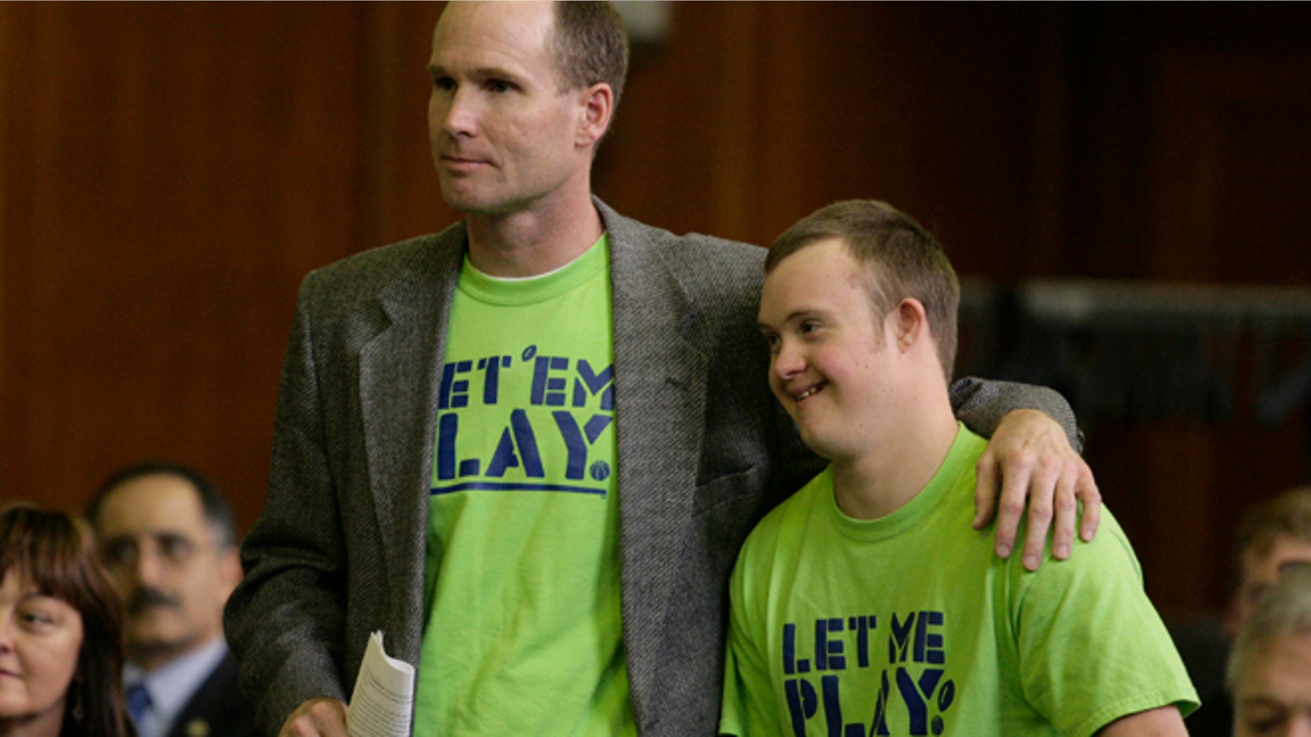 May 2, 2012: Dean Dompierre, left, and his son, Eric Dompierre, are introduced before they testify at a state Senate committee hearing in Lansing, Mich. Dompierre is supporting an age-limit waiver that would allow his son with Down syndrome to play sports next season.