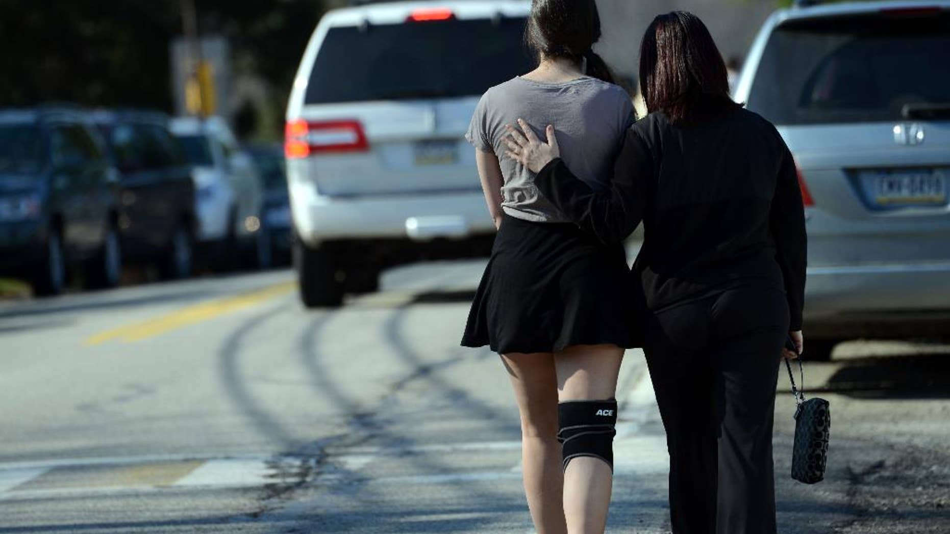 A parent consoles their child as the leave Franklin Regional High School after more than a dozen students were stabbed by a knife wielding suspect at the school on Wednesday, April 9, 2014, in Murrysville, Pa., near Pittsburgh. The suspect, a male student, was taken into custody and is being questioned. (AP Photo/Tribune Review, Sean Stipp) PITTSBURGH OUT