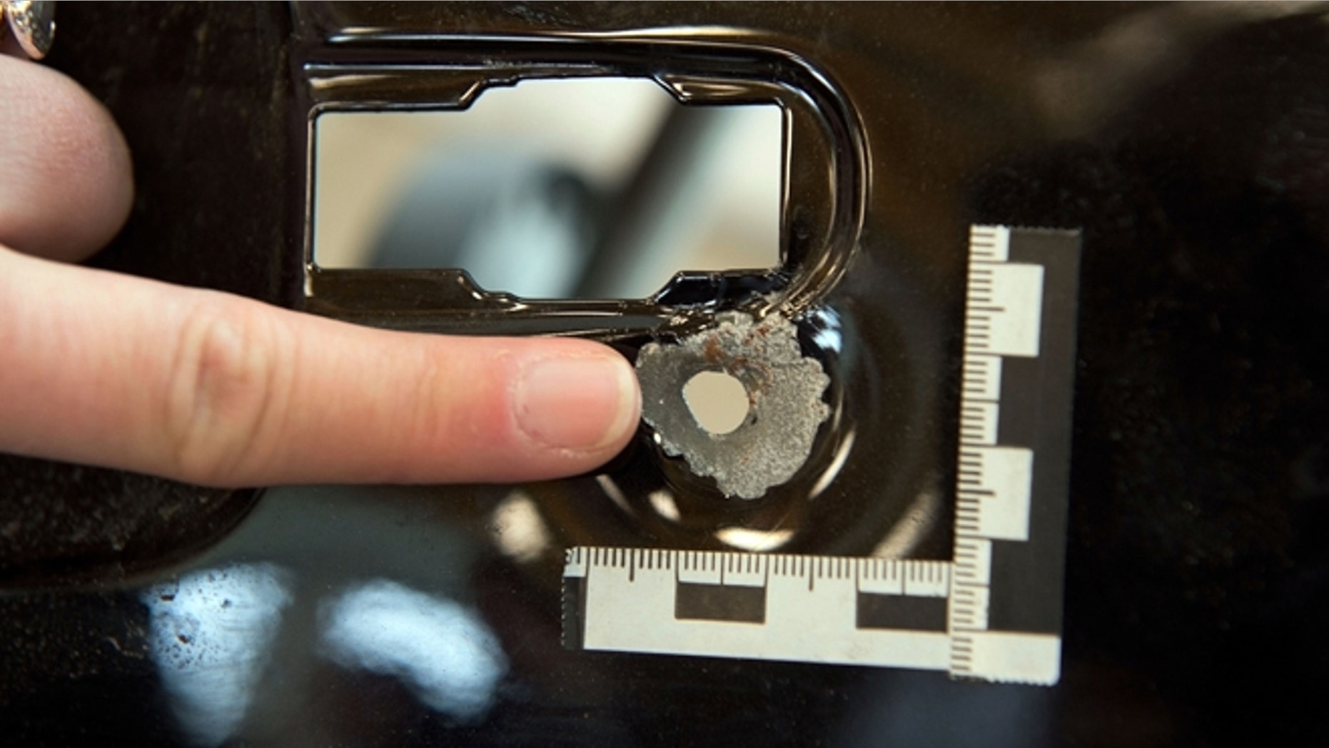 Nov. 20: An employee of the Federal Bureau of Criminal Investigation points at a bullet hole found in a car at the BKA headquarters in Wiesbaden, central Germany.