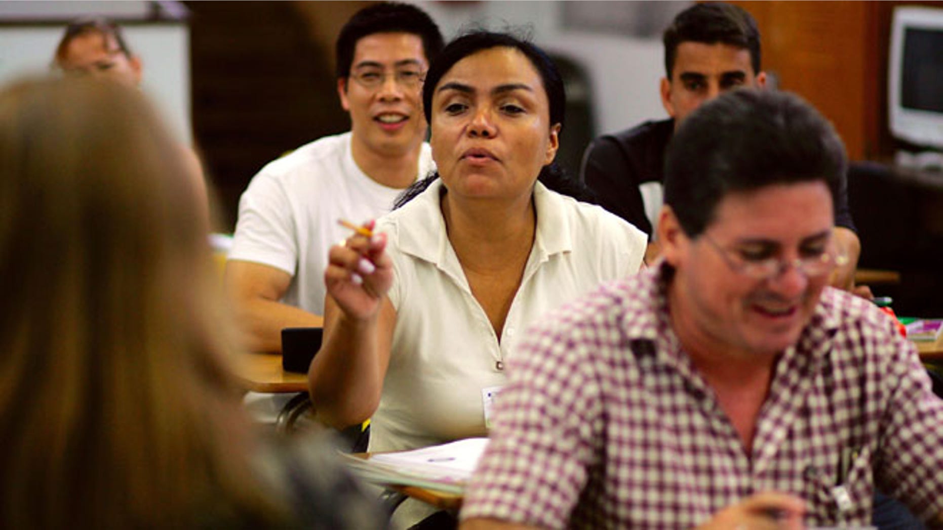 MIAMI - JUNE 16: Macela Medina, originally from Colombia, answers a question as she sits in her English class at the English Center June 16, 2006 in Miami, Florida. Gustavo Sabillon, originally from Honduras, sits in front of her. The school holds adult education classes that include English language classes for people who have immigrated to the United States. U.S. President George W. Bush recently said, ?Part of the greatness of America is that we've been able to help assimilate people into our society... And part of that assimilation process is English. I belie ve this: If you learn English, and you're a hard worker, and you have a dream, you have the capacity from going from picking crops to owning the store, or from sweeping office floors to being an office manager.? (Photo by Joe Raedle/Getty Images)