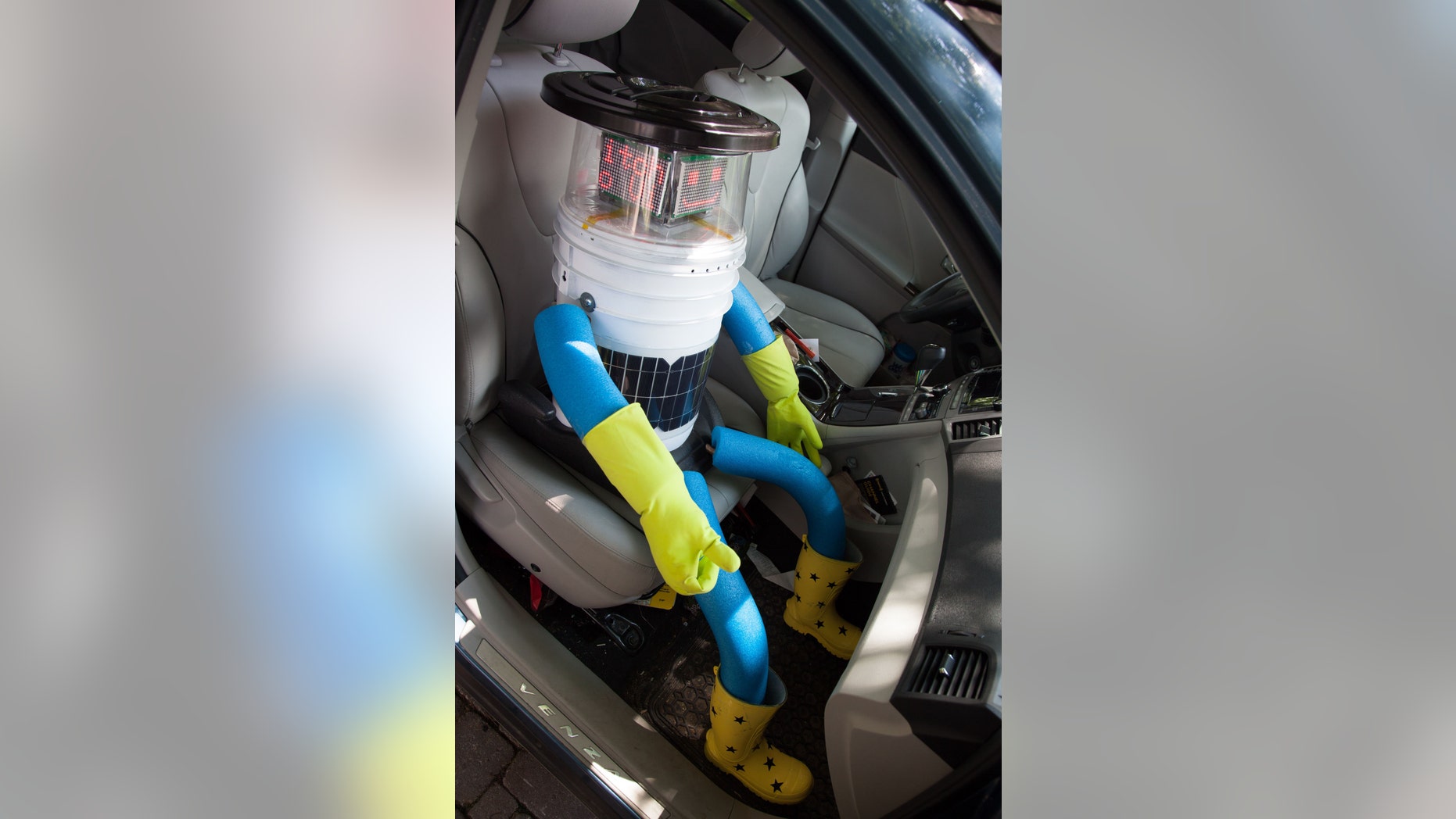 This undated photo made available by Ryerson University in Toronto on Thursday, Aug. 14, 2014 shows hitchBOT in a car. The talking robot that's been hitchhiking rides from strangers to travel from Canada's east to west coast is nearing the end of its journey. Its final destination is Victoria, British Columbia, Canada which its creators expect it to reach by Aug. 17, 2014. (AP Photo/Ryerson University)