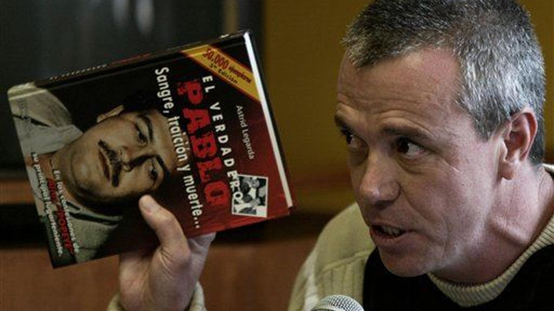 In this June 27, 2006, photo, Jhon Jairo Velasquez, a former hit man for Pablo Escobar, testifies while holding a book titled "The True Pablo: Blood, Treason, and Death."