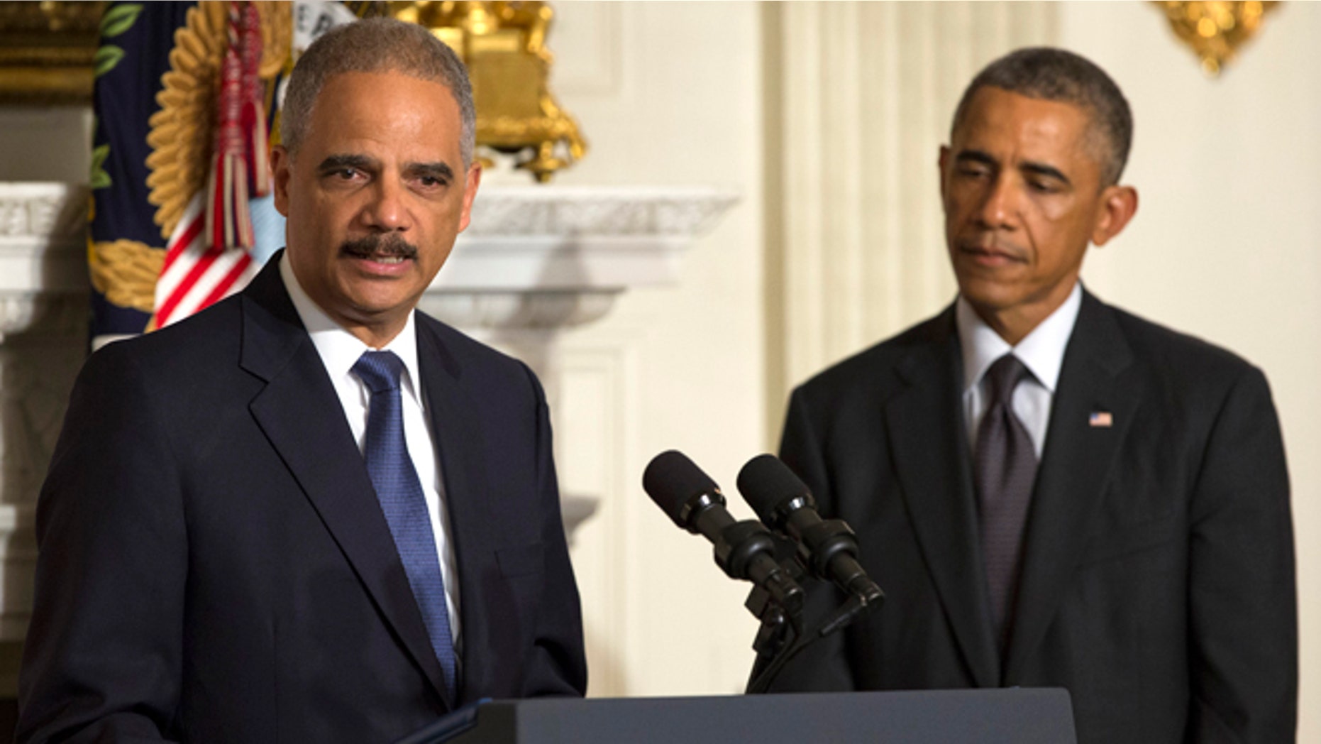 In this Thursday, Sept. 25, 2014 photo, President Barack Obama, right, looks on as Attorney General Eric Holder speaks in the State Dining Room of the White House, in Washington.