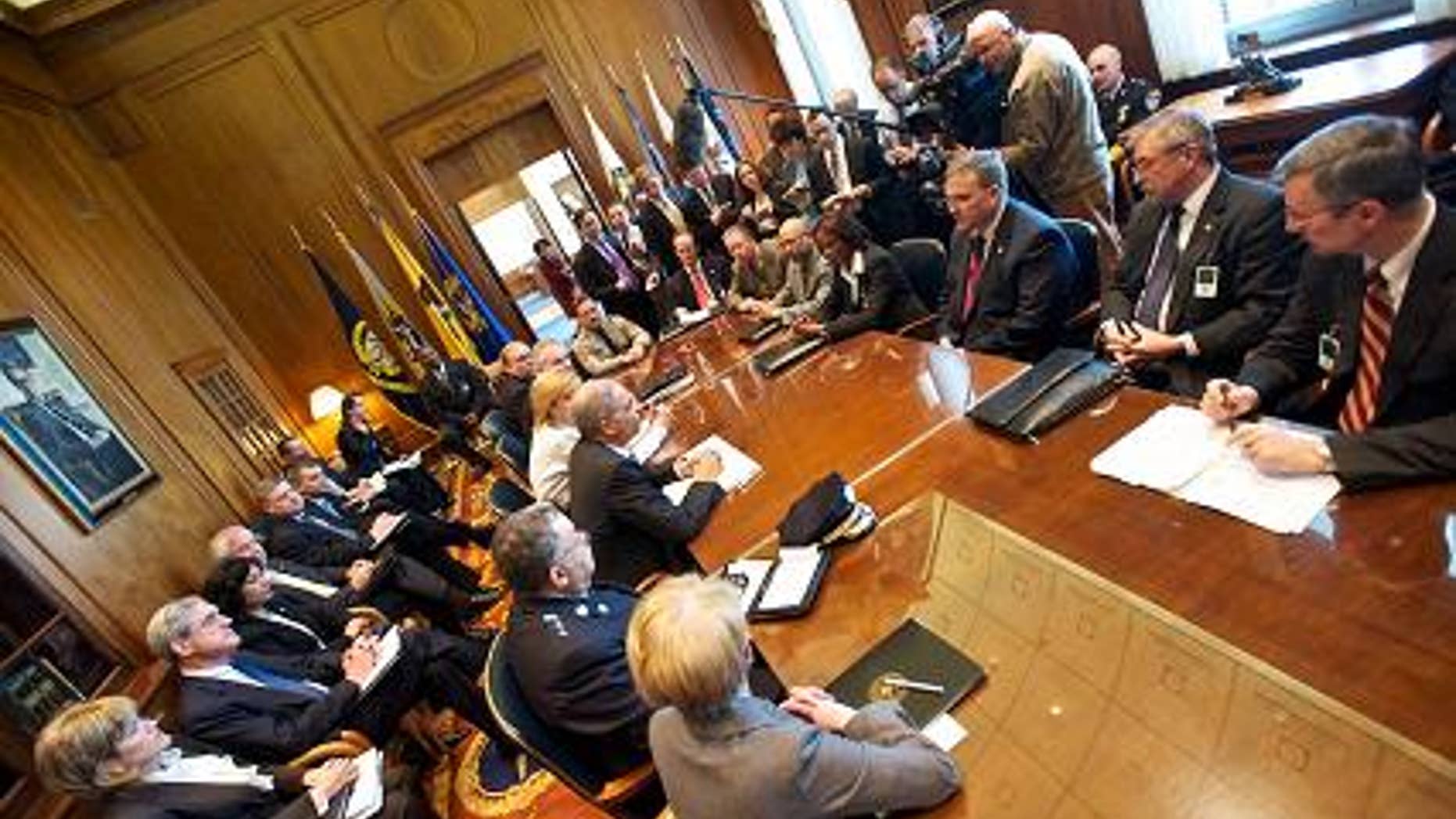 Reporters listen to Attorney General Eric Holder before his meeting with police officials, March 22