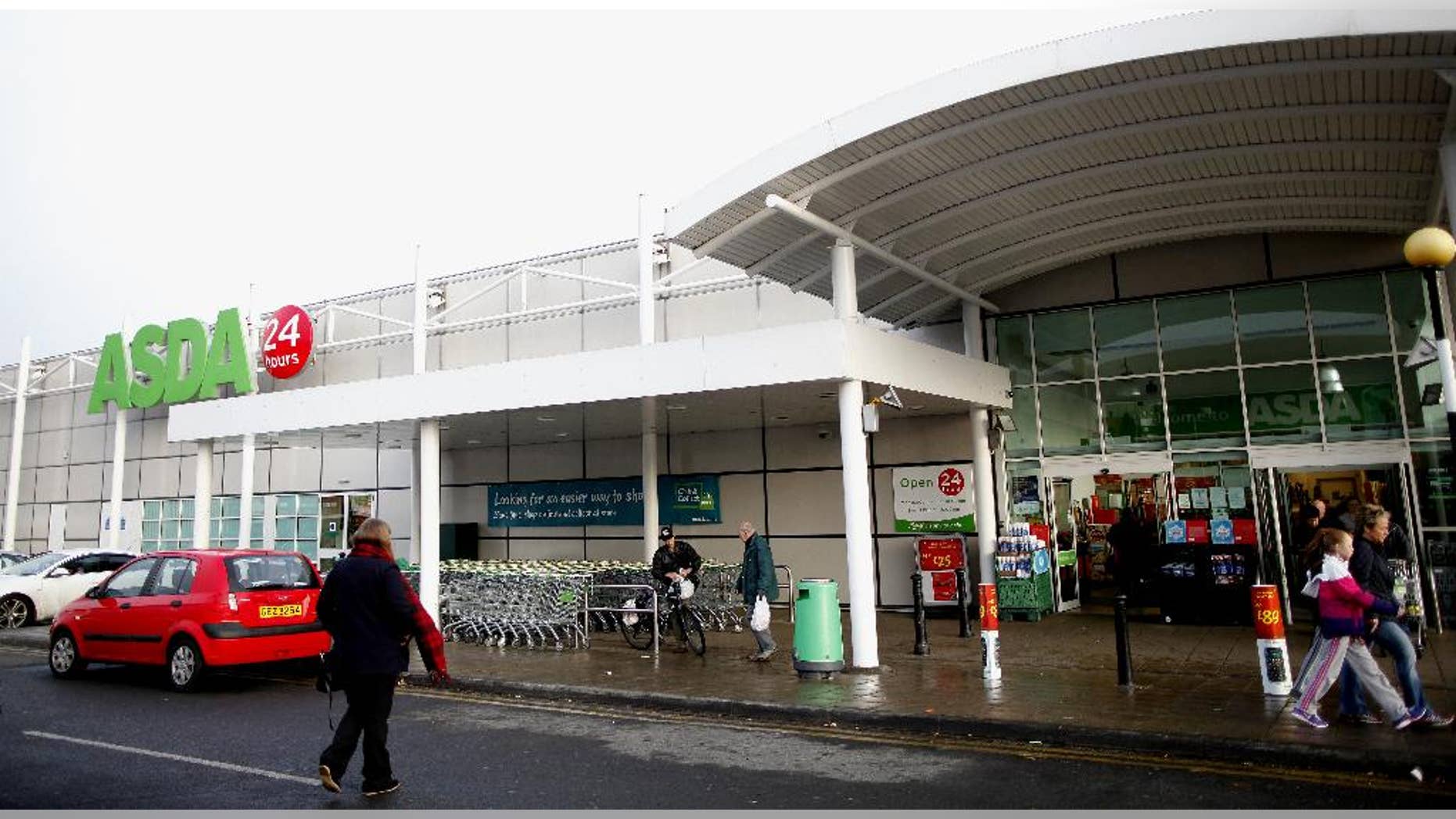 FILE - This is a Friday, Nov. 29, 2013 file photo of shoppers at the entrance to Asda supermarket store in West Belfast, Northern Ireland after at least one person was injured and taken to hospital from the store earlier Friday, as shoppers rushed to get their hands on sale deals for their Black Friday event. Halloween and Mother’s Day have become staples of the U.K. shopping calendar. Now Black Friday looks as though it may be the next big retail import from the United States. Shopping on the day after Thanksgiving is becoming a thing in Britain, too even if the country doesn’t celebrate Turkey day thanks mainly to the marketing efforts of major retailers. Asda, is owned by U.S. retail giant Walmart, (AP Photo/Peter Morrison, FILE)