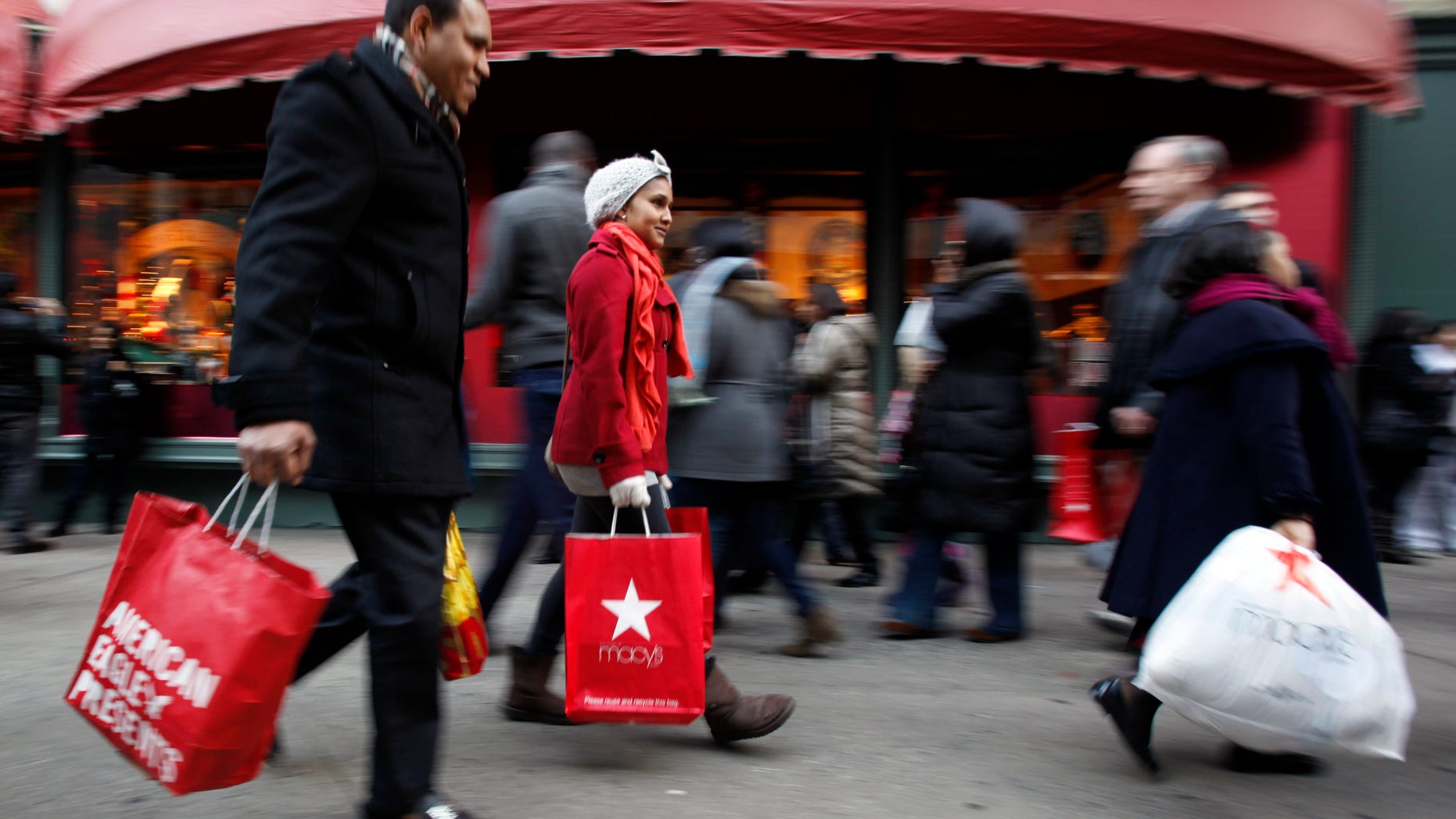 Dec. 18: Shopping bags in hand, consumers walk down 34th Street in New York. Retailers saw a spike in holiday shopping the last weekend before Christmas as retail revenue went up 5.5 percent.
