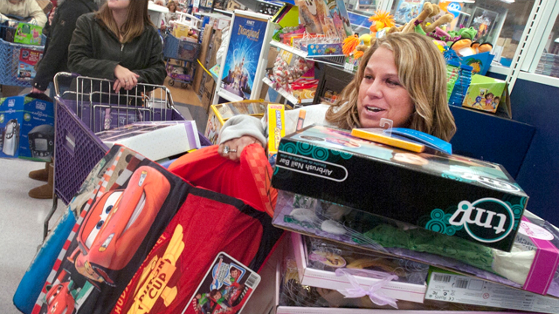 Nov. 24: Kerry Neiderer has her hands and chin full of toys as she waits on line at Toys R' Us in West Manchester Township, Pa.
