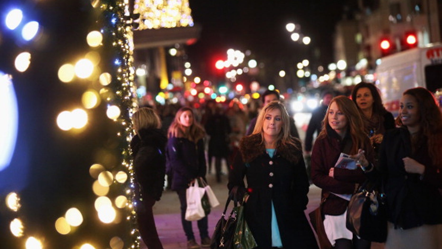 LONDON, ENGLAND - NOVEMBER 29: Shoppers admire the Christmas window displays of Harrods department store in Knightsbridge on November 29, 2012 in London, England. Many prominent retailers in the capital have produced elaborate festive window displays to entice Christmas shoppers with less than one calendar month remaining before Christmas Day. (Photo by Oli Scarff/Getty Images)