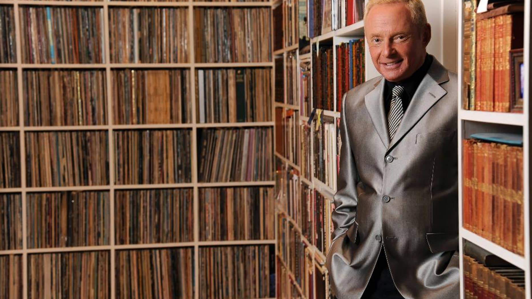 April 29, 2014 photo, Elliot Mintz poses for a portrait in his library at his home in Beverly Hills, Calif. Determined to retire after five decades in Hollywood, the 69-year-old is releasing what he calls a “cyberography”: A free website filled with more than 150 hours of his radio and TV interviews comprising hundreds of celebrities and subjects.
