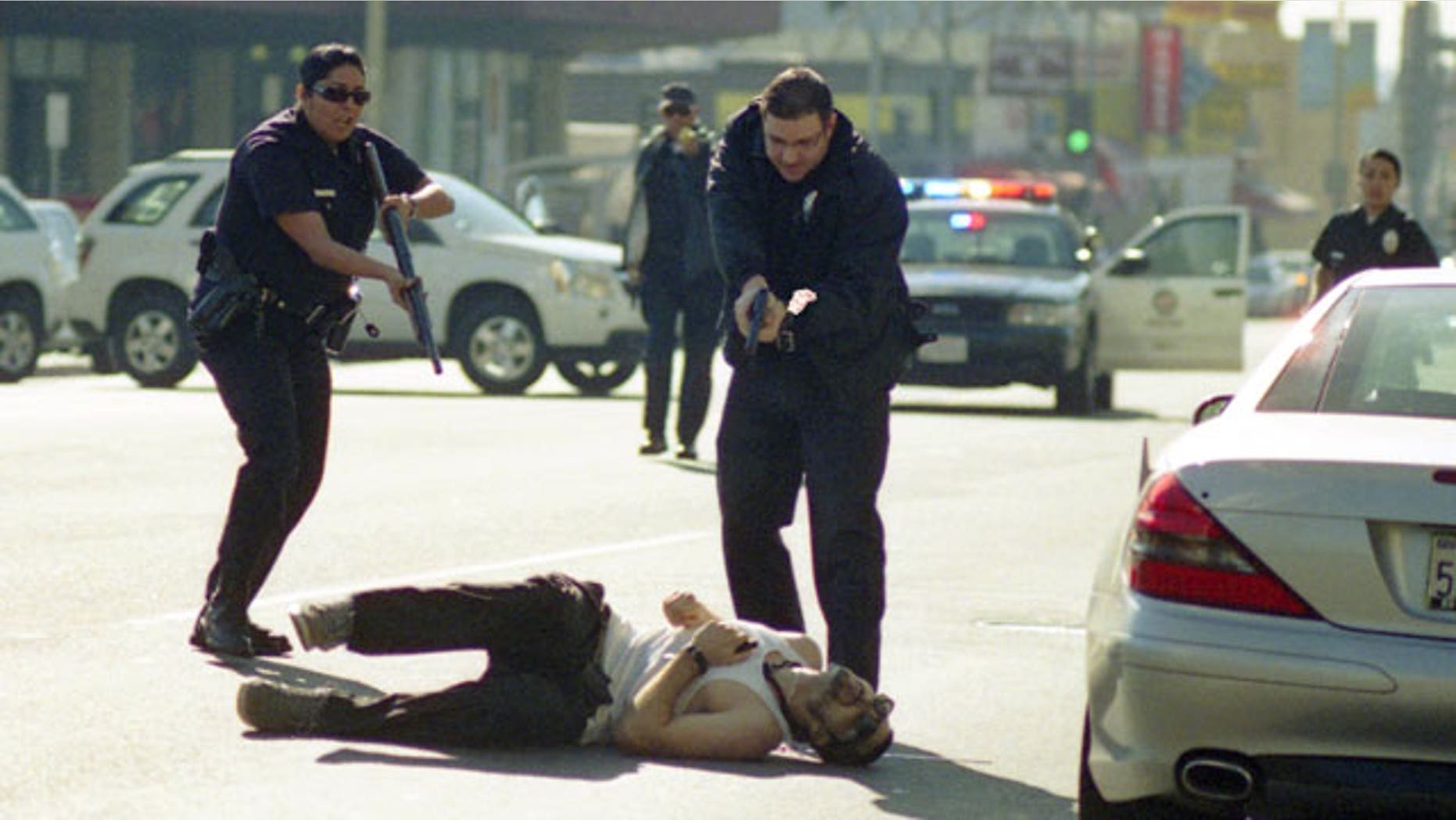 December 9, 2011: This image provided by Gregory Bojorquez shows Los Angeles Police officers advancing on a wounded gunman at sunset and Vine streets in Los Angeles.