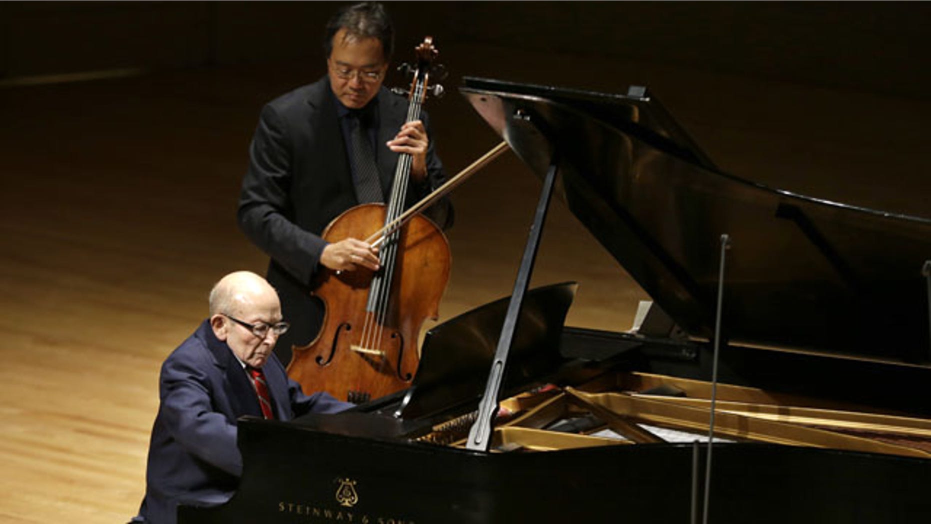 October 22, 2013: Holocaust survivor George Horner, front left, performs with cellist Yo-Yo Ma, top, on stage at Symphony Hall in Boston. The 90-year-old pianist made his orchestral debut with Ma, where they played music composed 70 years ago at the Nazi concentration camp where Horner was imprisoned. (AP Photo/Steven Senne)