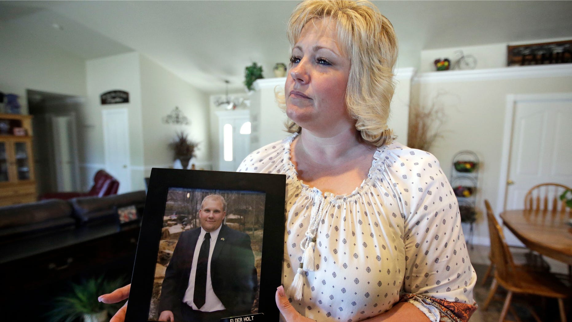 Laurie Holt holds a photograph of her son Josh Holt at her home, in Riverton, Utah, on July 13, 2016.